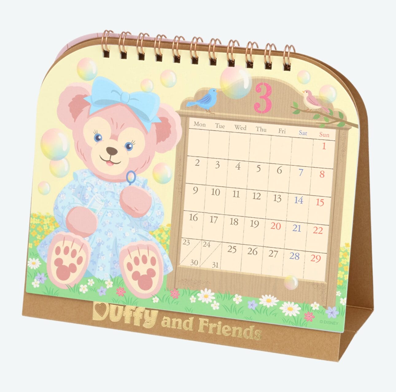A cute bear in blue sits by a March calendar on a colorful 2026 Calendars "Duffy and Friends" desk stand.