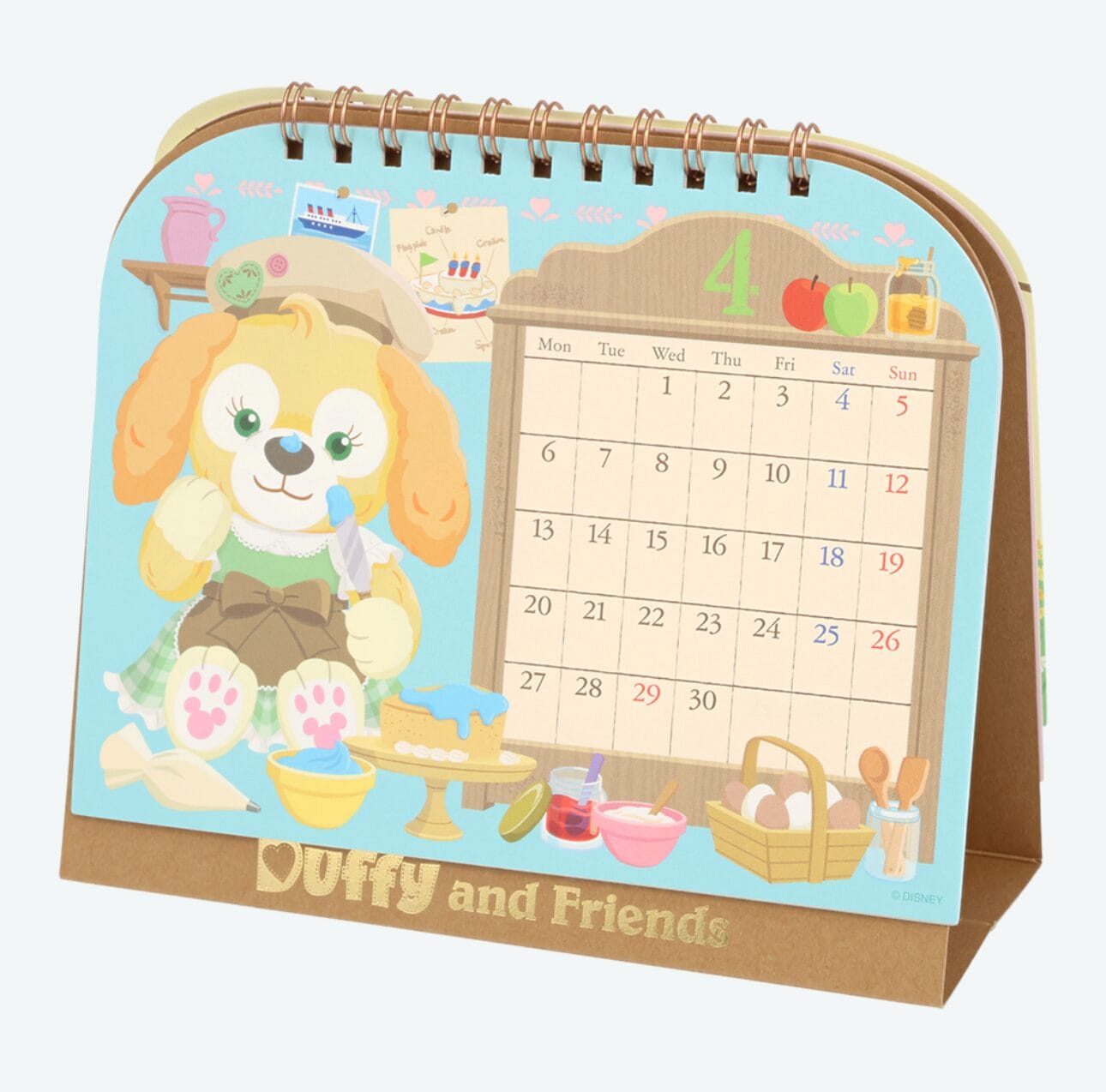 Spiral desk calendar with a cute dog illustration, baking items, and April 2026 displayed—perfect for planners.