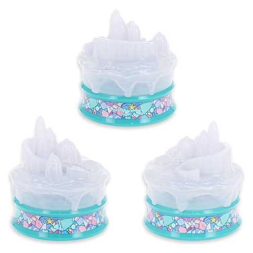 Three small, icy castle cake toppers with blue bases decorated with mosaic and star patterns.