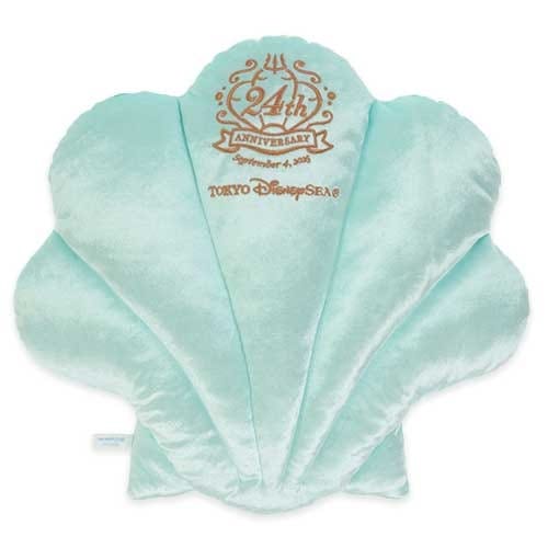 A light blue shell-shaped pillow with “24th Anniversary” and DisneySea logo embroidered in gold on top.