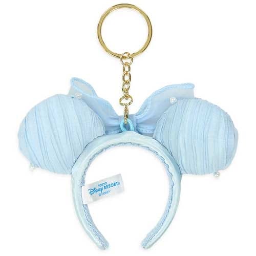 Light blue Minnie Mouse ear headband keychain with a bow, Disney tag, and gold keyring attached.