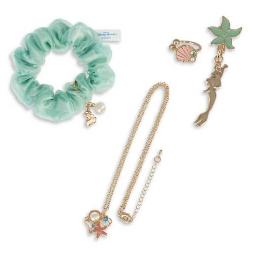 Mint green scrunchie, necklace, ring, and earrings with gold and mermaid-themed charms on a white background.