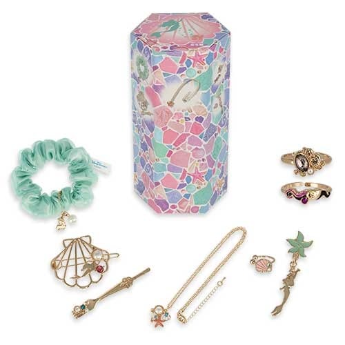 Jewelry and accessories set with rings, pins, a necklace, a bracelet, and a scrunchie, next to a colorful hexagonal box.