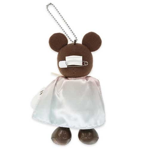 Plush bear keychain with a white cape and bandage over one eye, attached to a metal chain.