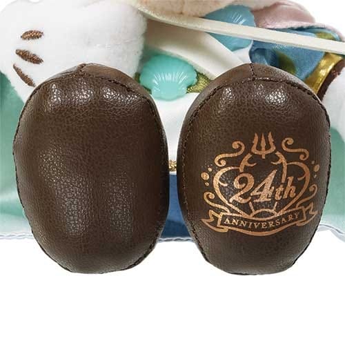 Two brown oval objects with "24th Anniversary" and a trident design printed on one, made of leather-like material.