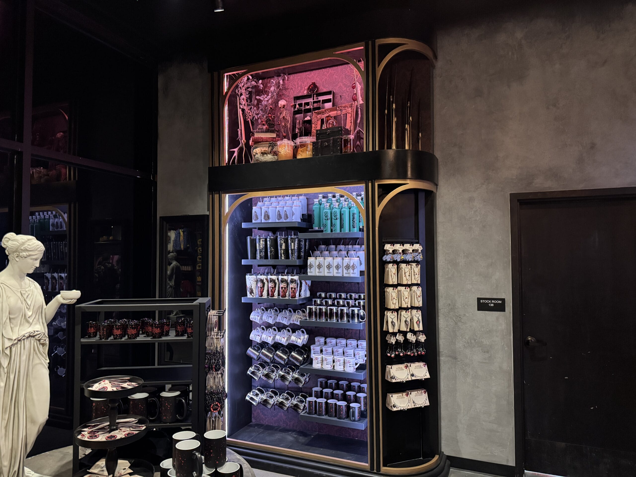 A store display at Universal Horror Unleashed in Las Vegas, with themed souvenirs, potions, and dramatic red-purple lighting.