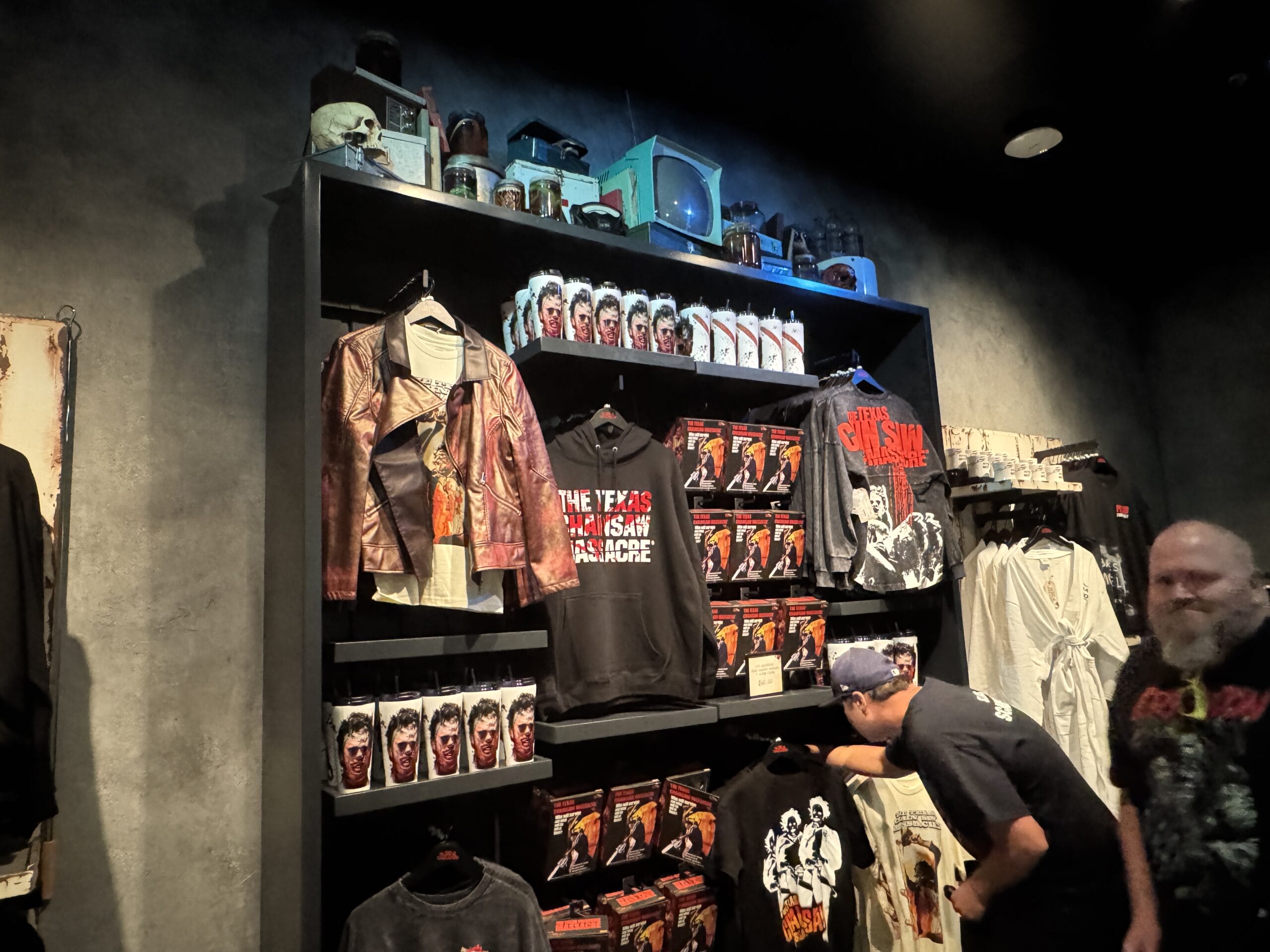 A store display at Universal Horror Unleashed in Las Vegas features "The Texas Chainsaw Massacre" shirts, mugs, and jackets.