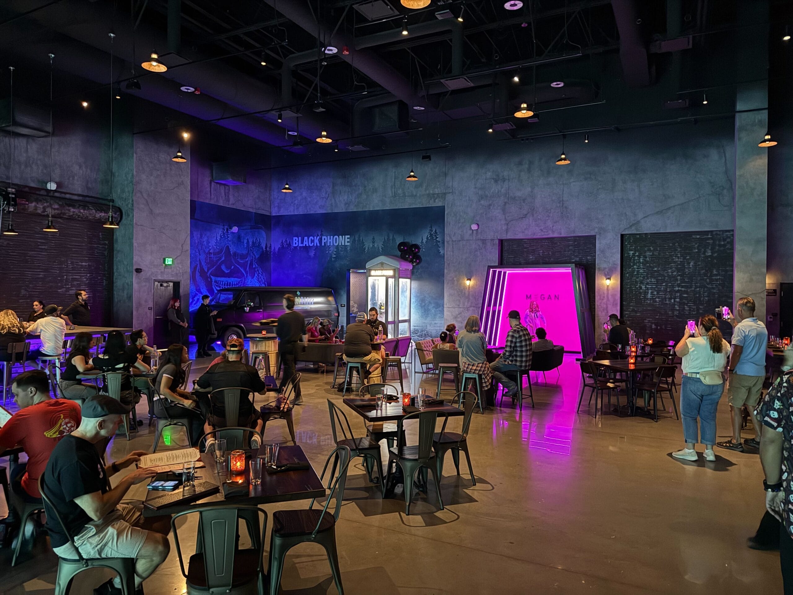 People gather in a dimly lit, neon-filled space at Universal Horror Unleashed in Las Vegas.