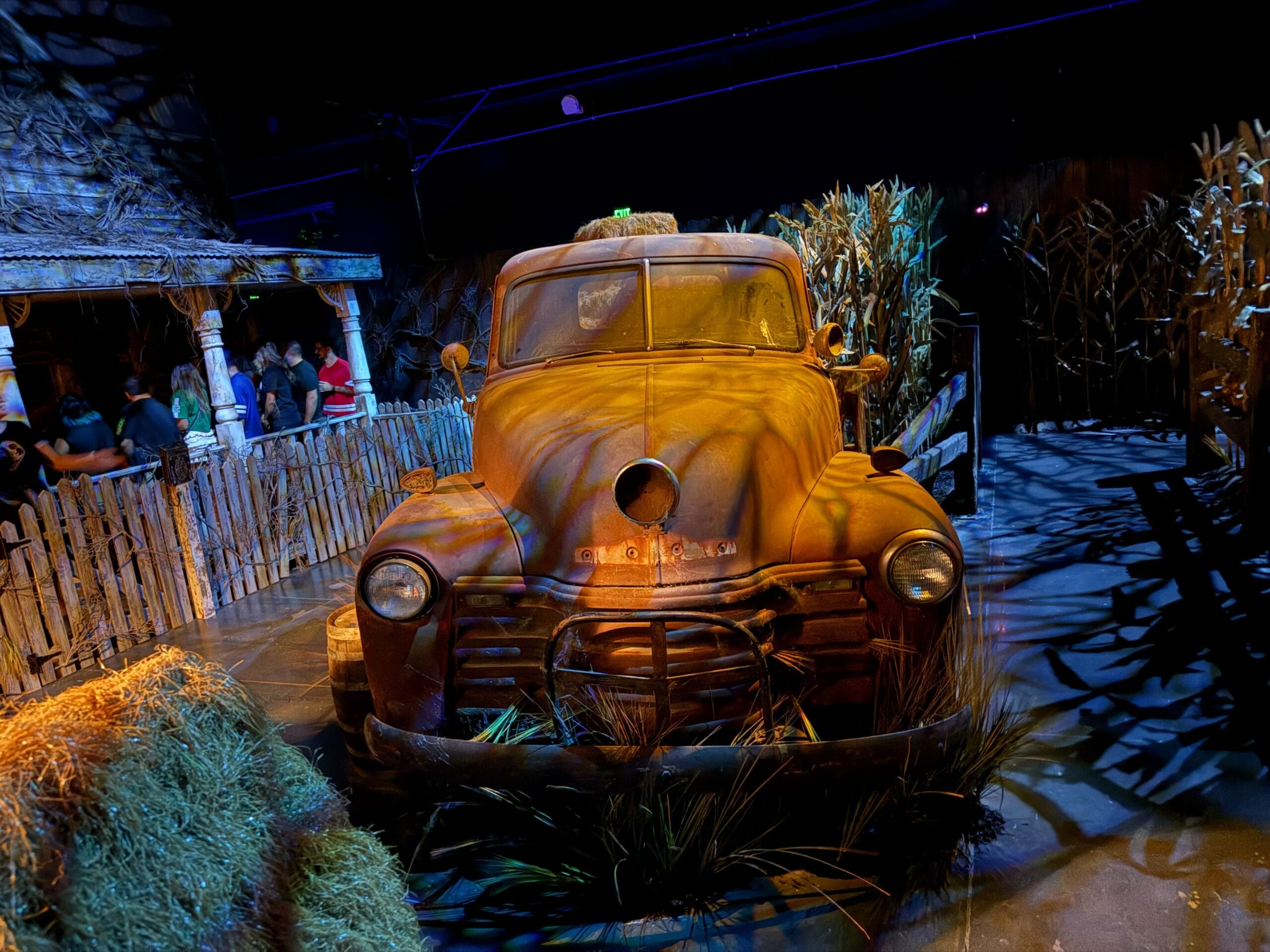 Rusty vintage truck with hay and cornstalks in a spooky indoor Las Vegas setting—Universal Horror Unleashed Full Tour.