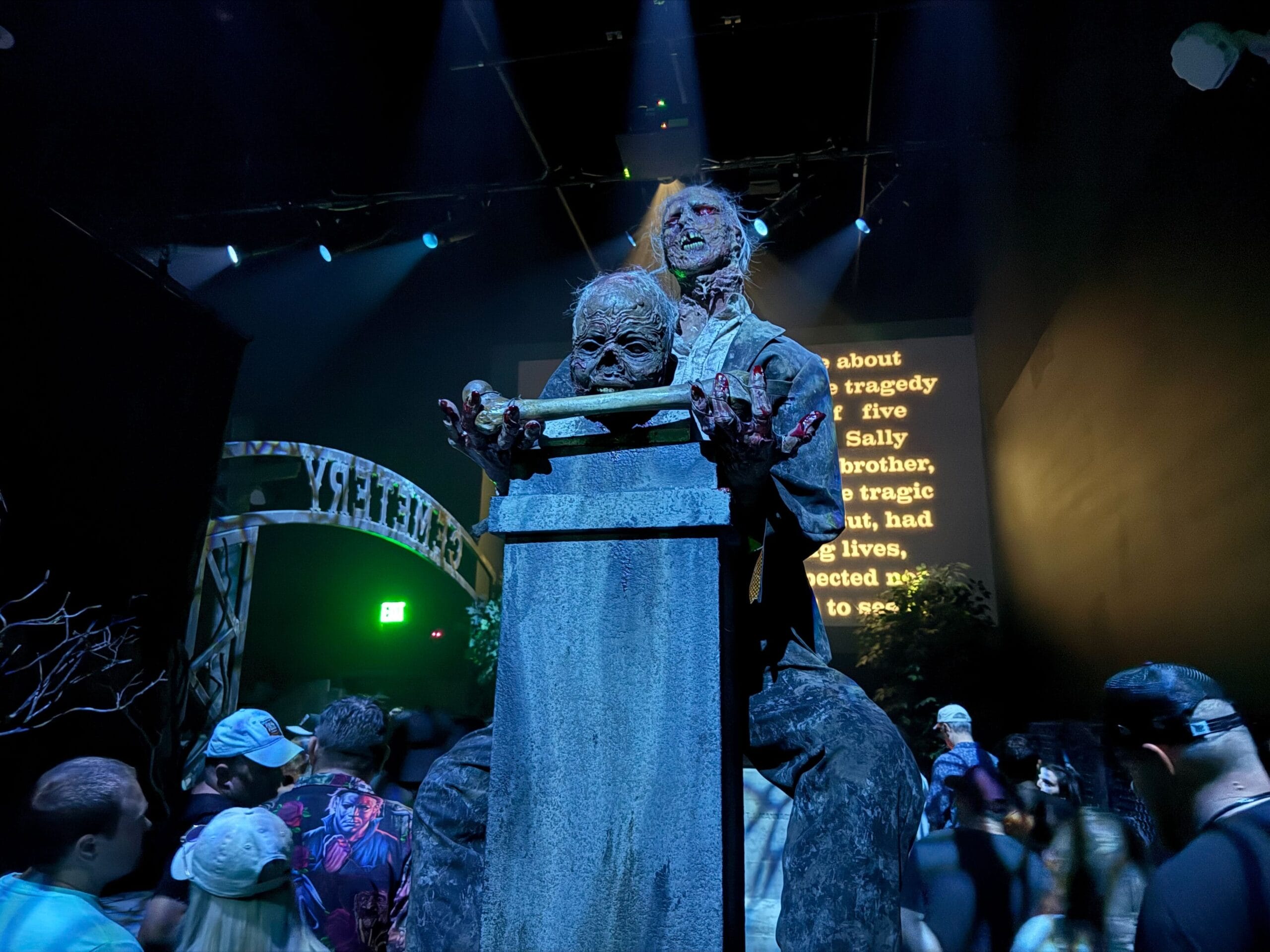 Two creepy zombie figures loom on a tall stone pedestal at Universal Horror Unleashed in Las Vegas's haunted house.