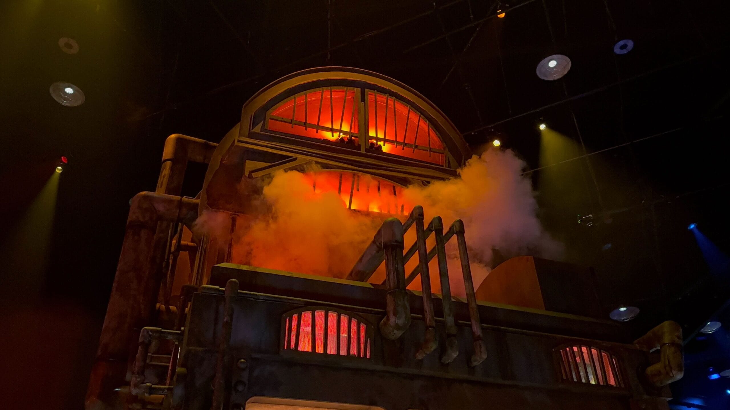 A large, industrial machine emits orange light and smoke on a dark stage—Universal Horror Unleashed in Las Vegas.