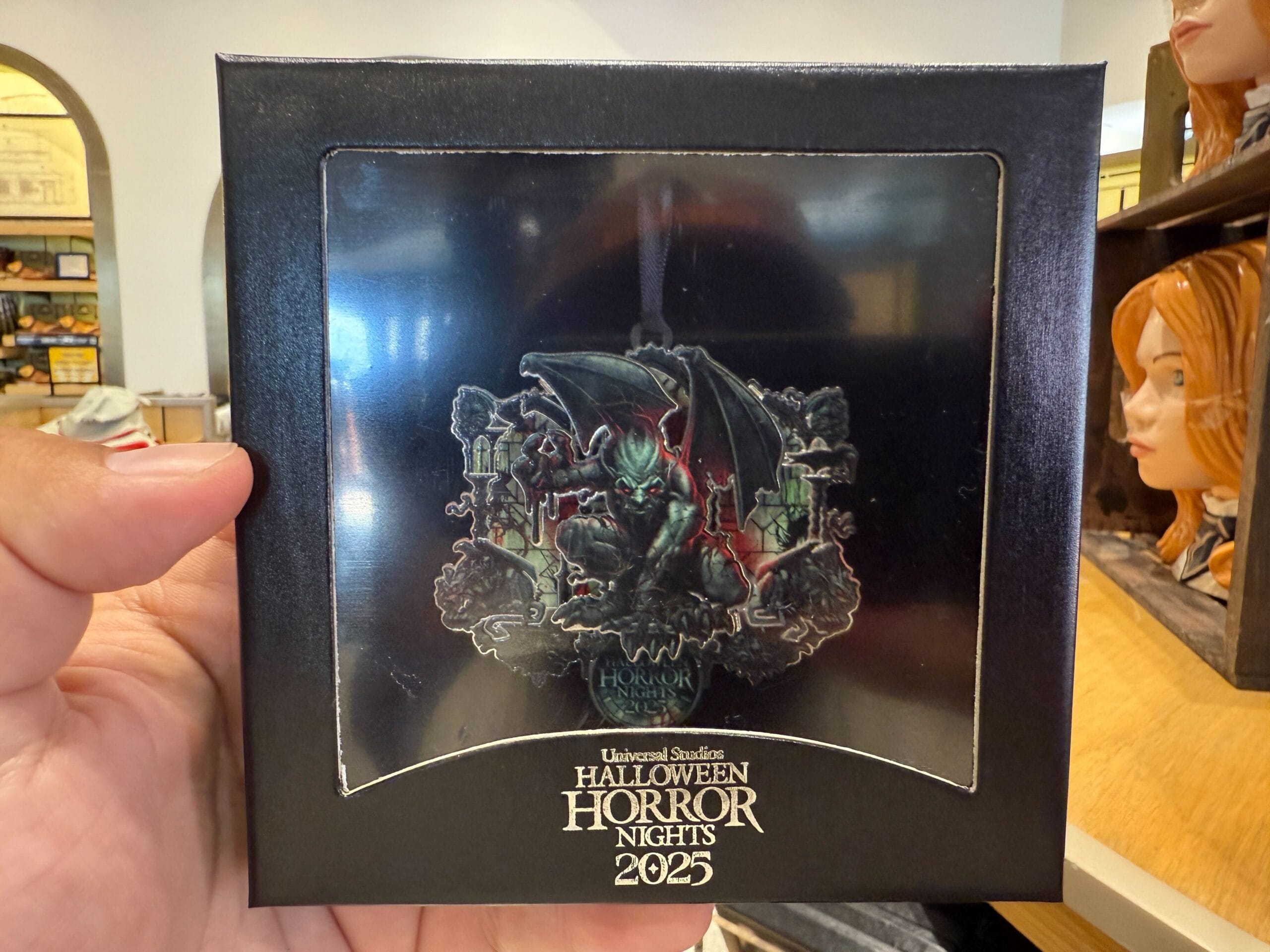 A hand holds exclusive HHN Merch 2025—a dark gargoyle collectible from Universal Orlando Resort’s spooky scene.