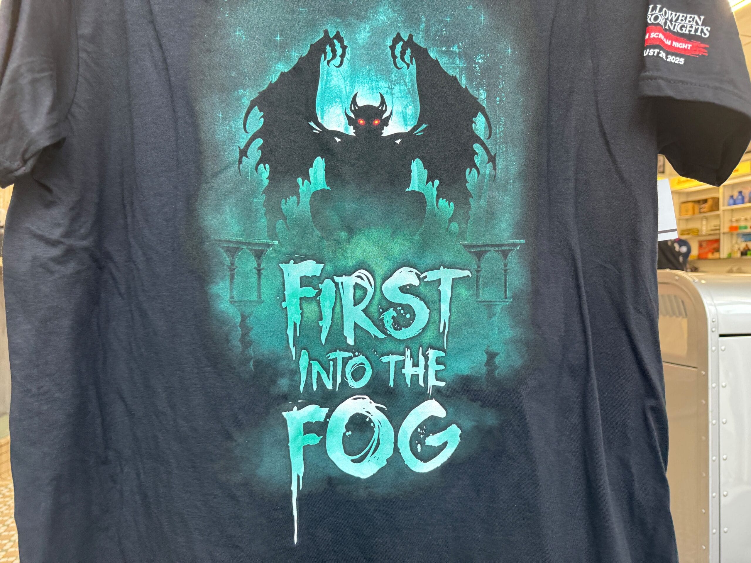 T-shirt with a dark demon-like figure, misty green fog, perfect for Scream Night or Halloween Horror Nights 2025.