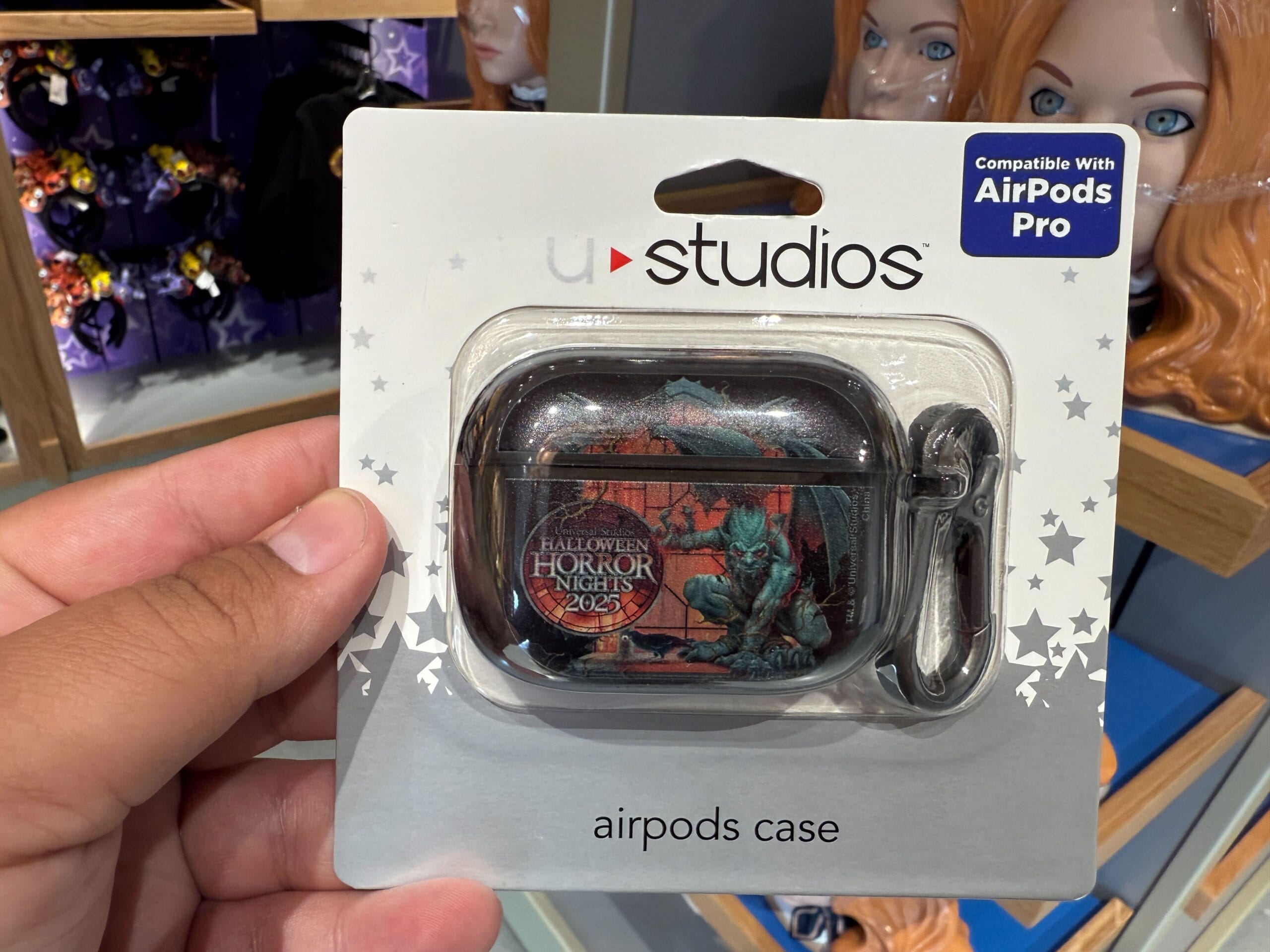 Hand holding an HHN Merch AirPods Pro case with a dragon, exclusive to Universal Orlando Resort.