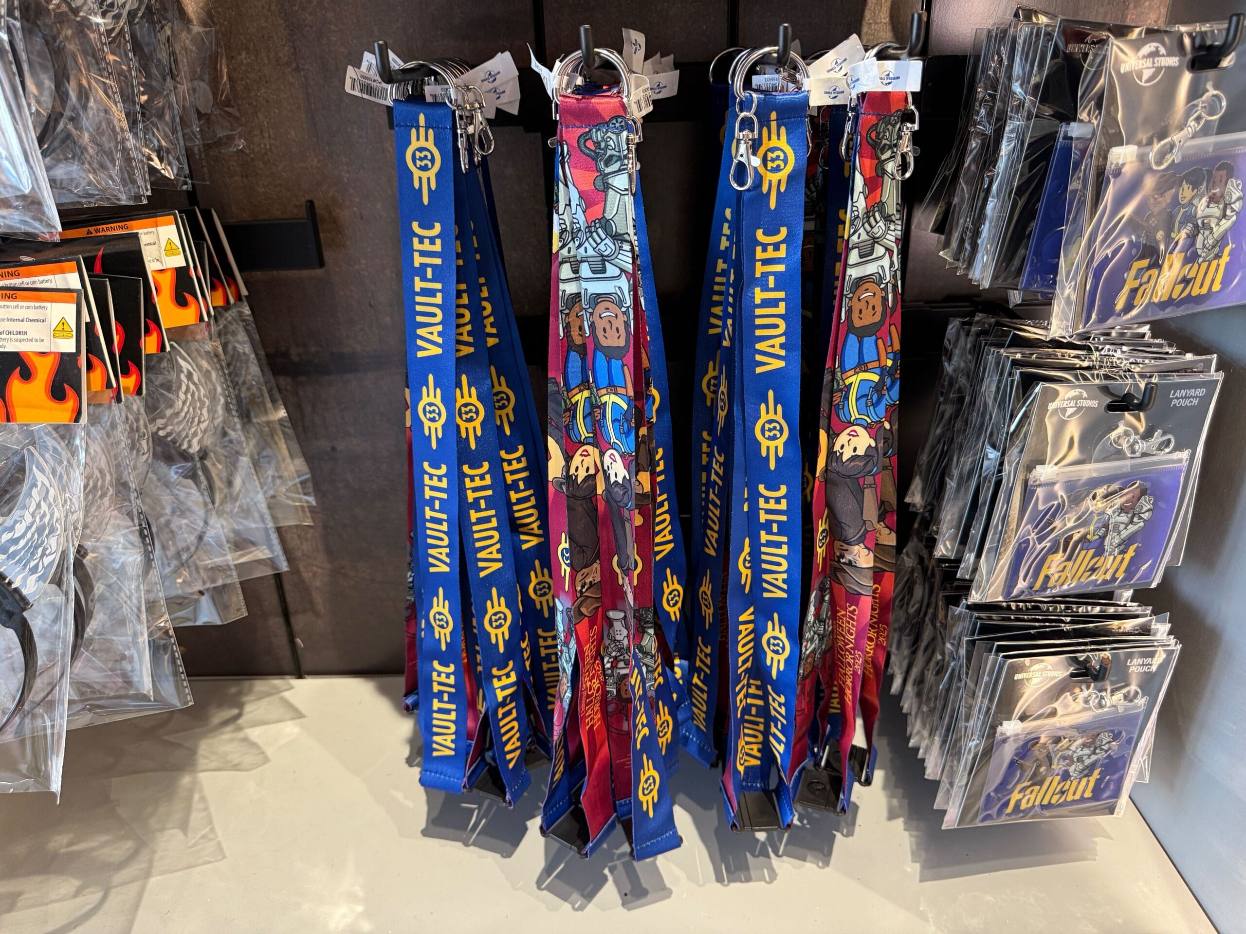 Vault-Tec and Fallout-themed lanyards displayed next to keychains and magnets at Universal Orlando Resort.