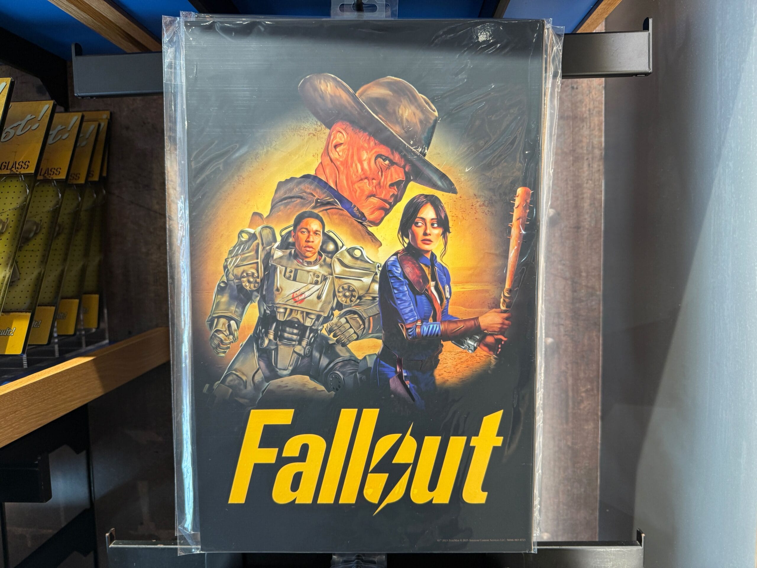 A "Fallout" poster featuring three characters in dramatic poses, exclusive HHN Merch at Universal Orlando Resort.