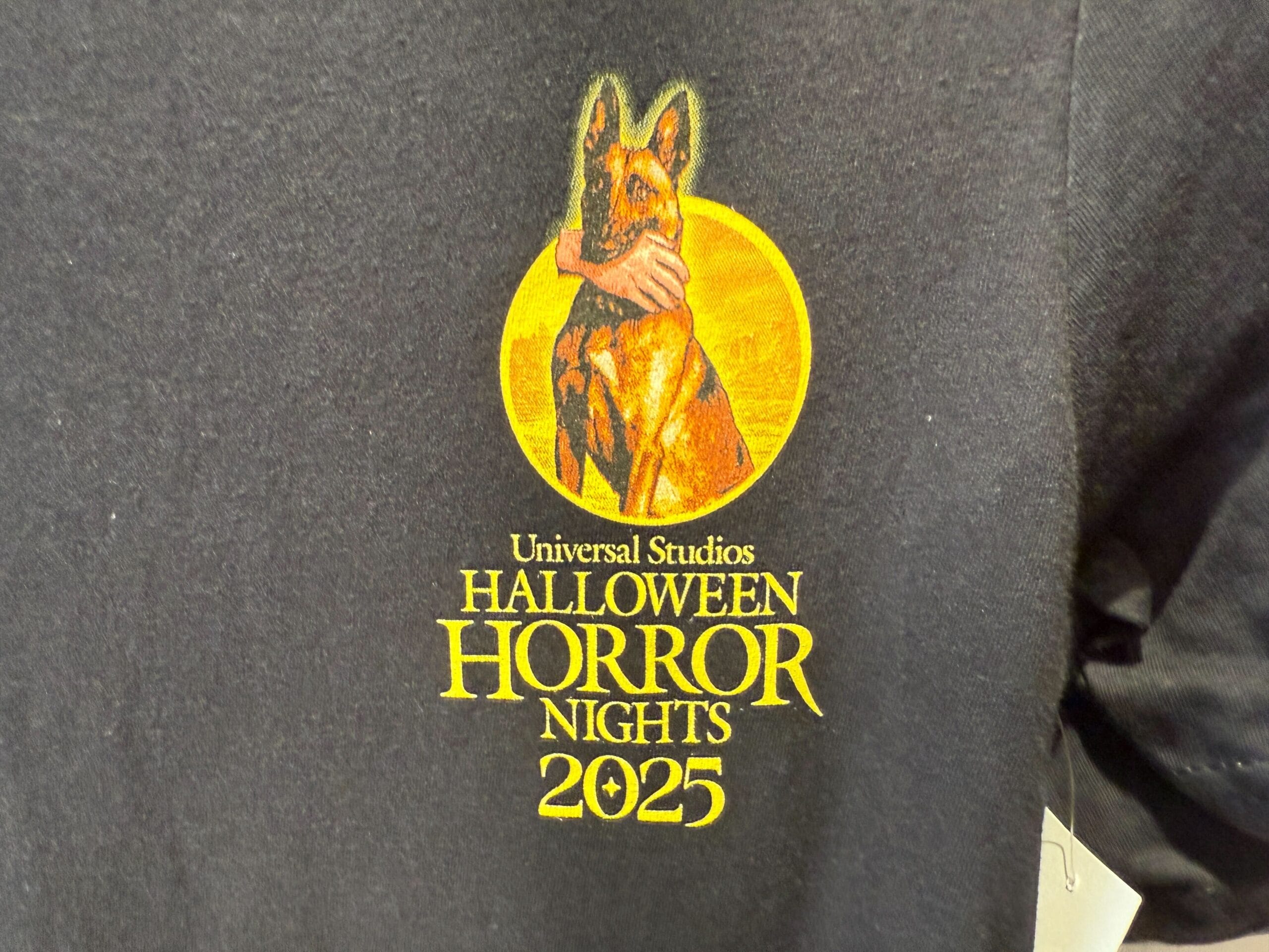 Universal Orlando Resort HHN merch: 2025 Halloween Horror Nights logo with a dog and hand on a black shirt.
