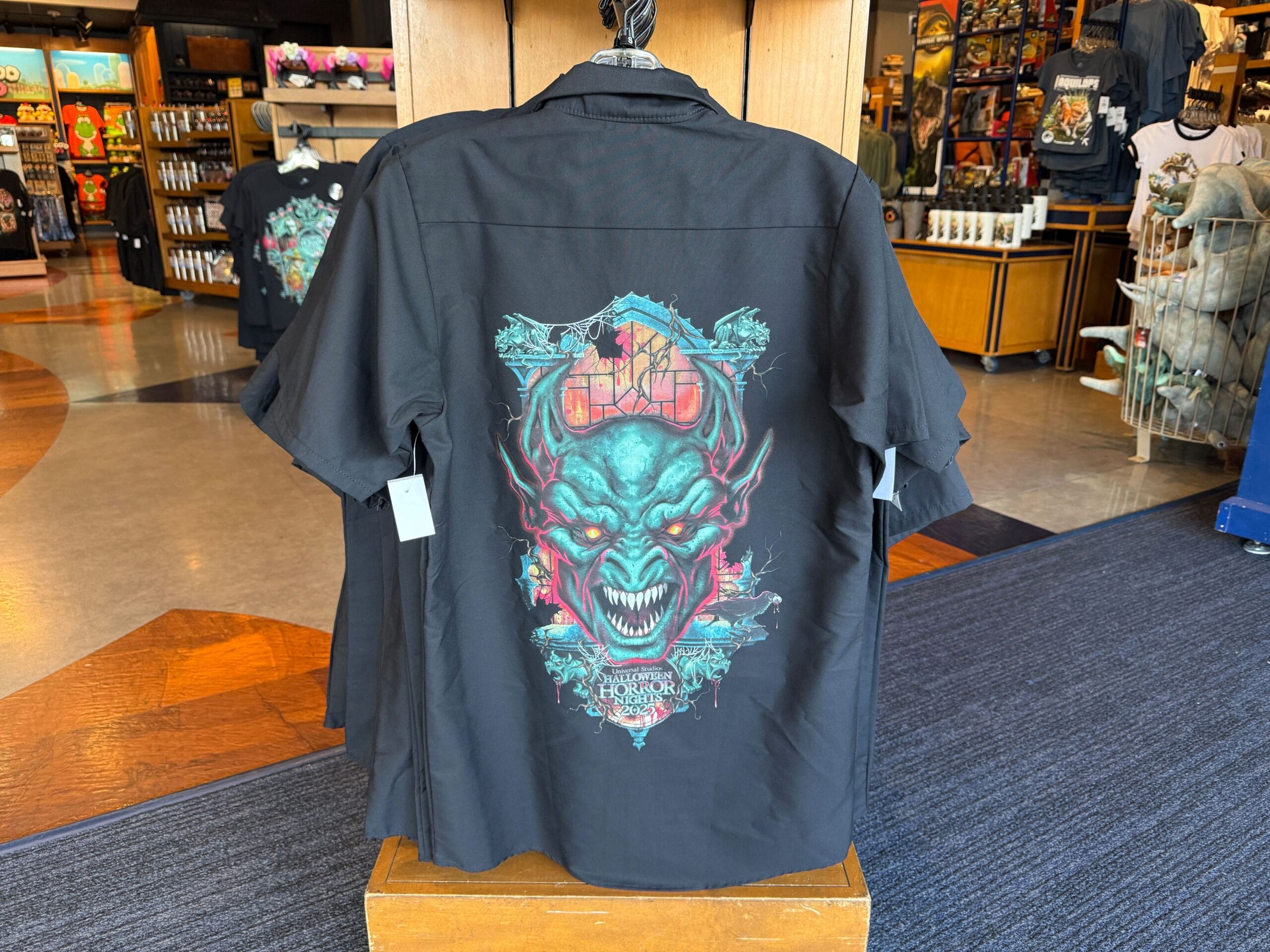 Black shirt with a colorful monster face and "Halloween Horror Nights 2025" logo, displayed at Universal Orlando Resort.