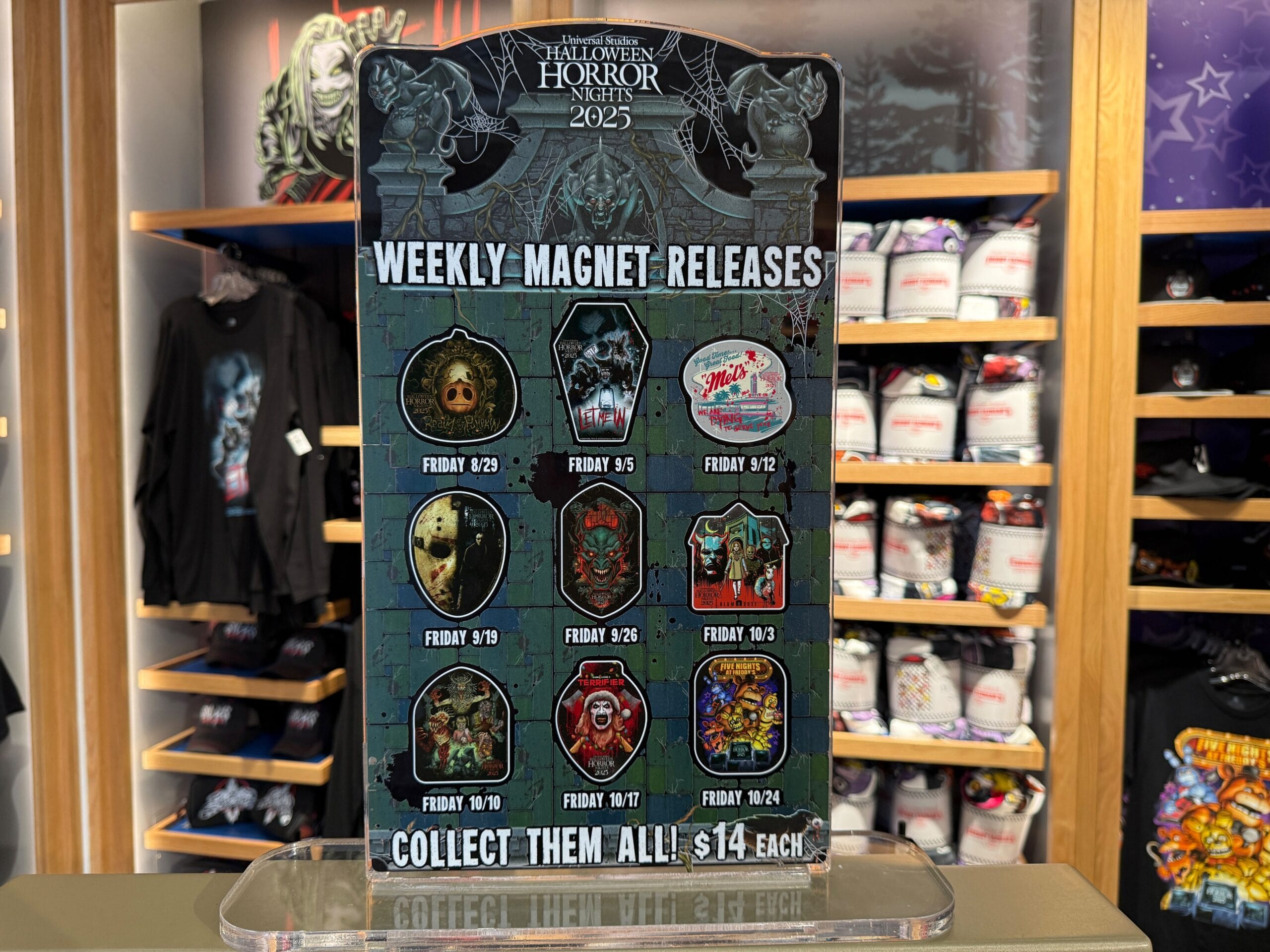 A sign inside Universal Orlando Resort displays HHN merch weekly magnet releases and pricing for Halloween Horror Nights.