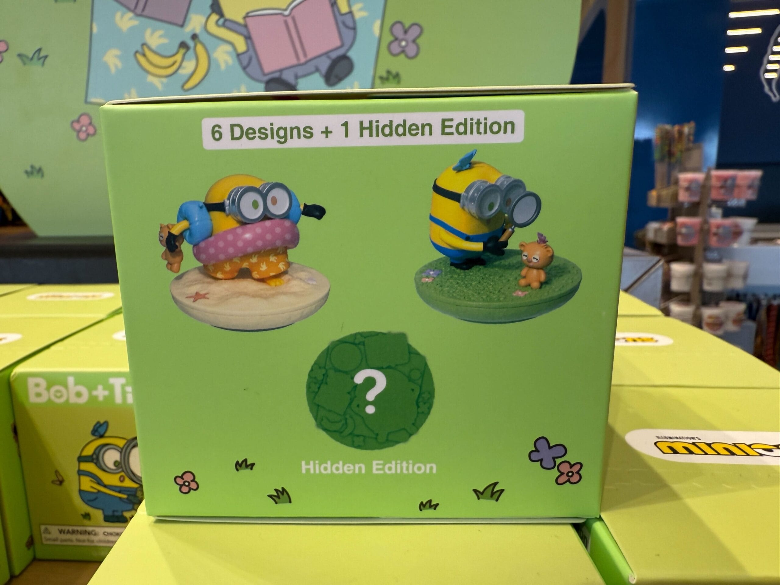 Box showing two Minions figurines and text: "6 Designs + 1 Hidden Edition" with a question mark for the hidden one.