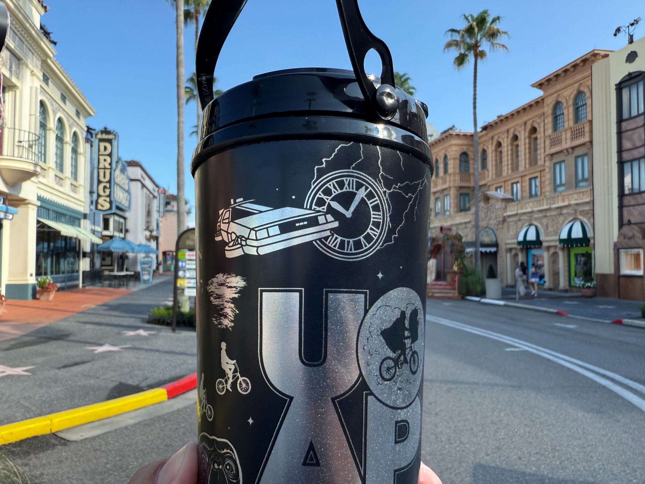 A UOAP Coca-Cola Freestyle Cup featuring movie icons on an empty street with palm trees and historic buildings.