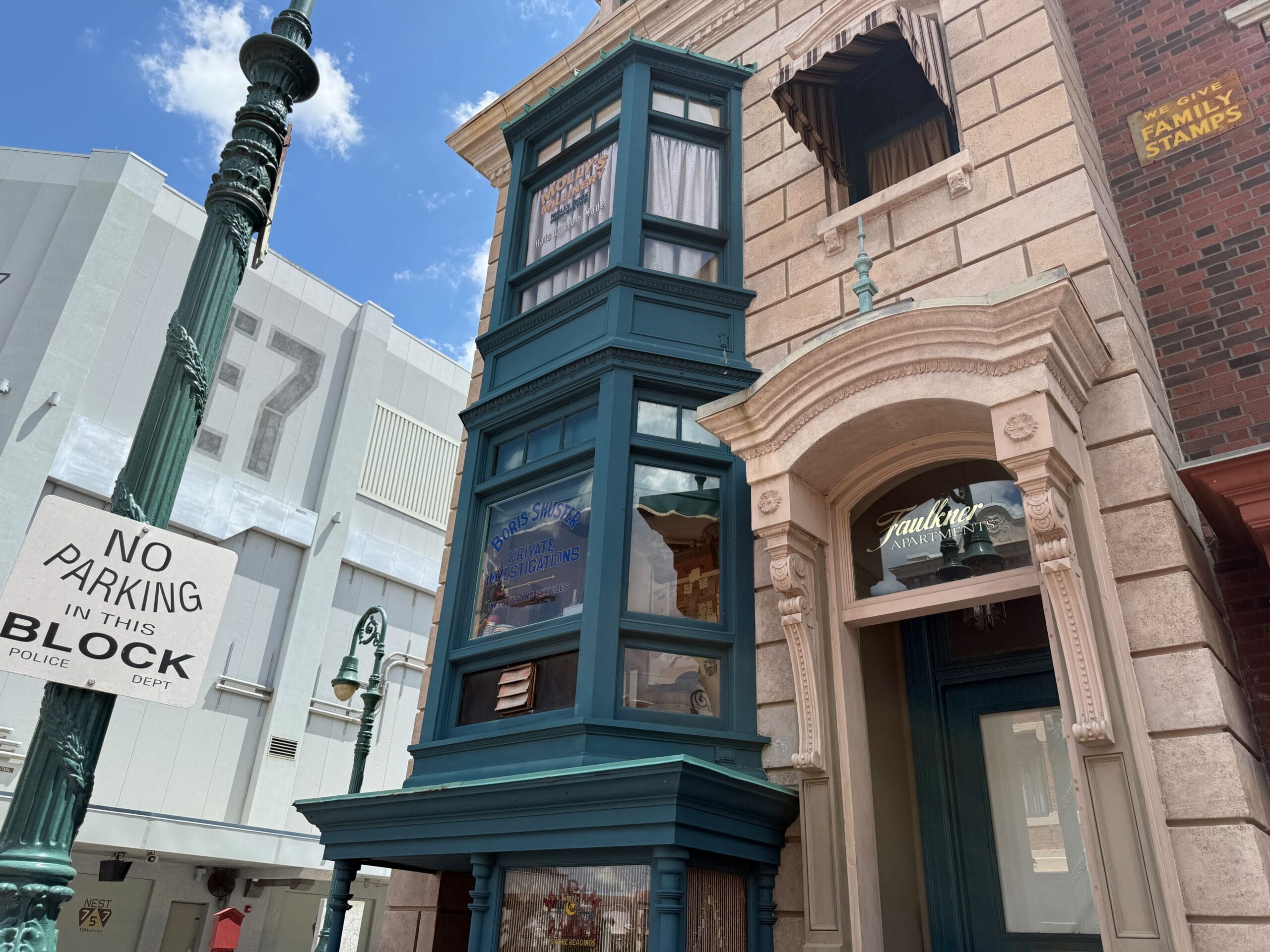 Street view of the Boris office building with teal window bays, a "No Parking" sign, and lamppost under blue sky.