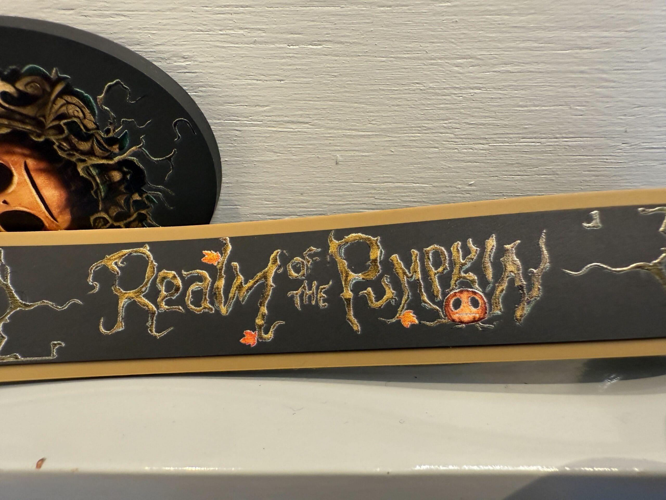 A sign reading "Realm of the Pumpkin" in spooky, vine-like letters, inspired by Lil Boo merchandise.