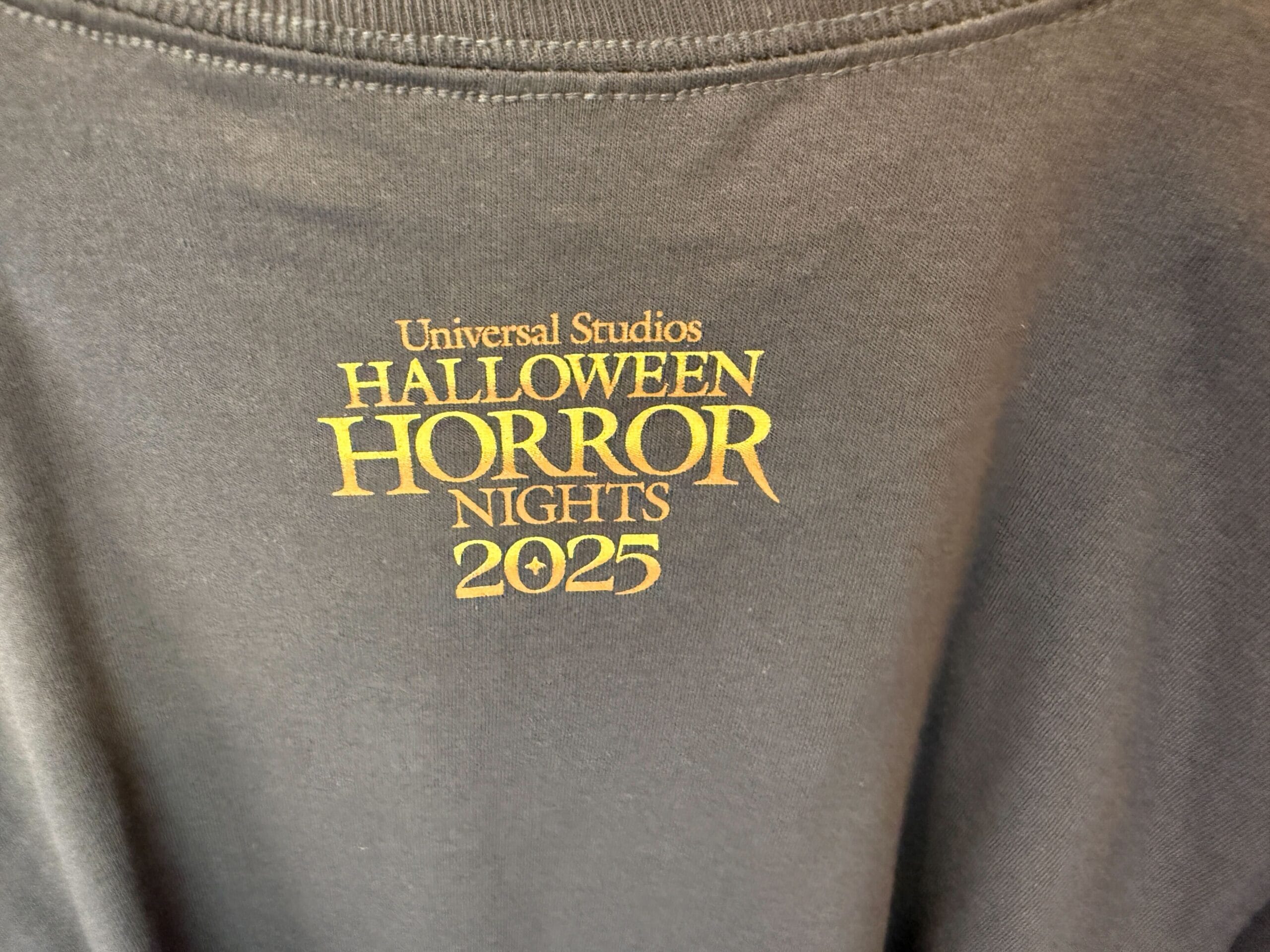 Close-up of Lil Boo merchandise: a shirt with yellow “Universal Studios Halloween Horror Nights 2025” text printed on it.