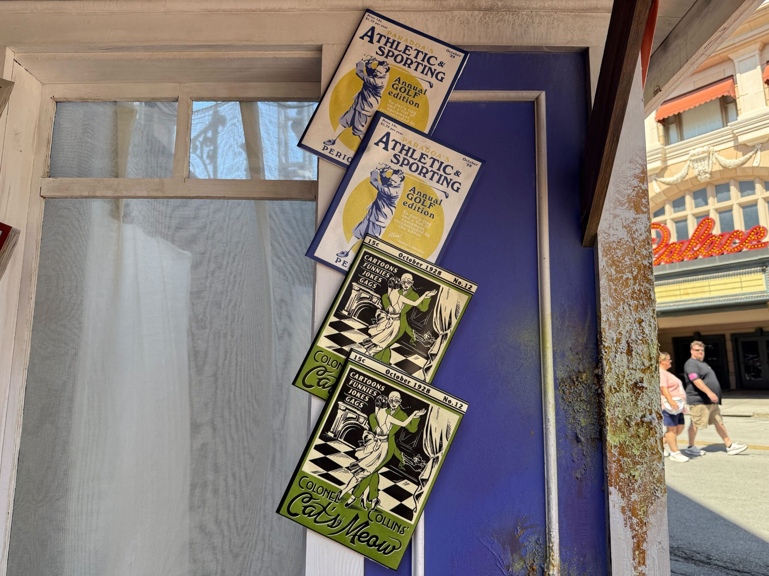 Four vintage-style posters hang on a blue door, two blue and two green, advertising events and dance classes.