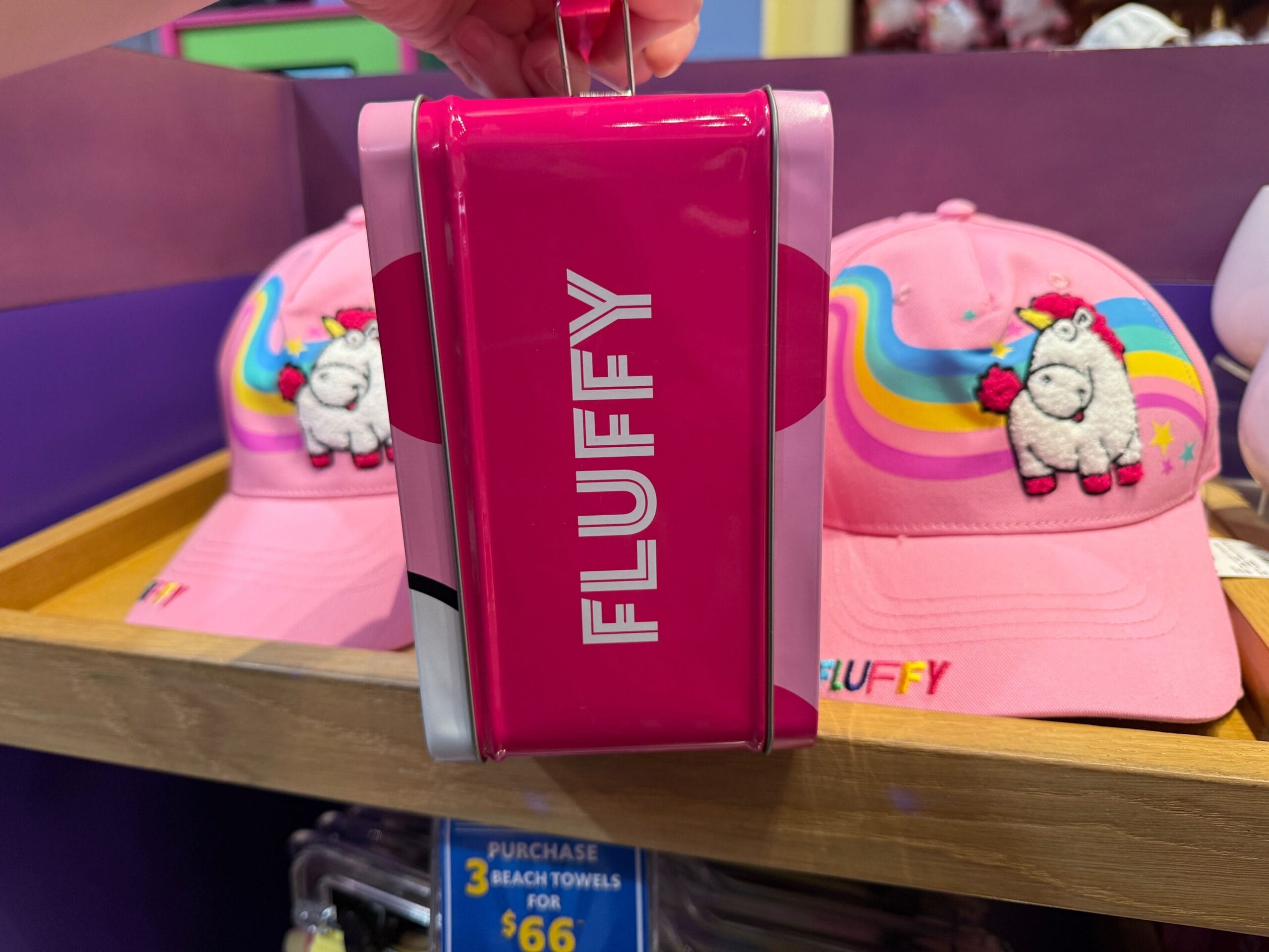 A pink box labeled "FLUFFY" sits before unicorn hats and rainbows, inspired by Universal Orlando Resort’s Fluffy Unicorn.