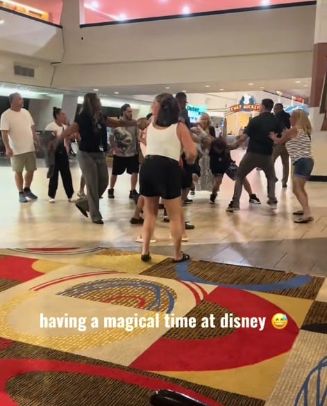 Contemporary resort fight- Group of people engaged in a violent fistfight indoors at Disney's Contemporary Resort, with "having a magical time at disney" overlaid.