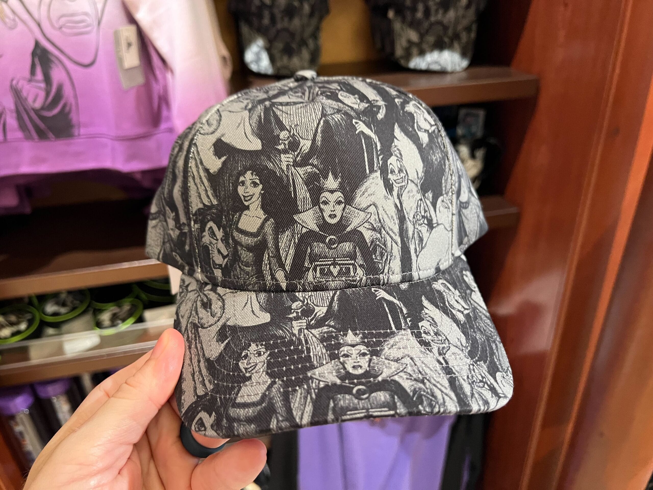 A black and white cap featuring Disney Villains merchandise, like the Evil Queen and Ursula, displayed in a store.