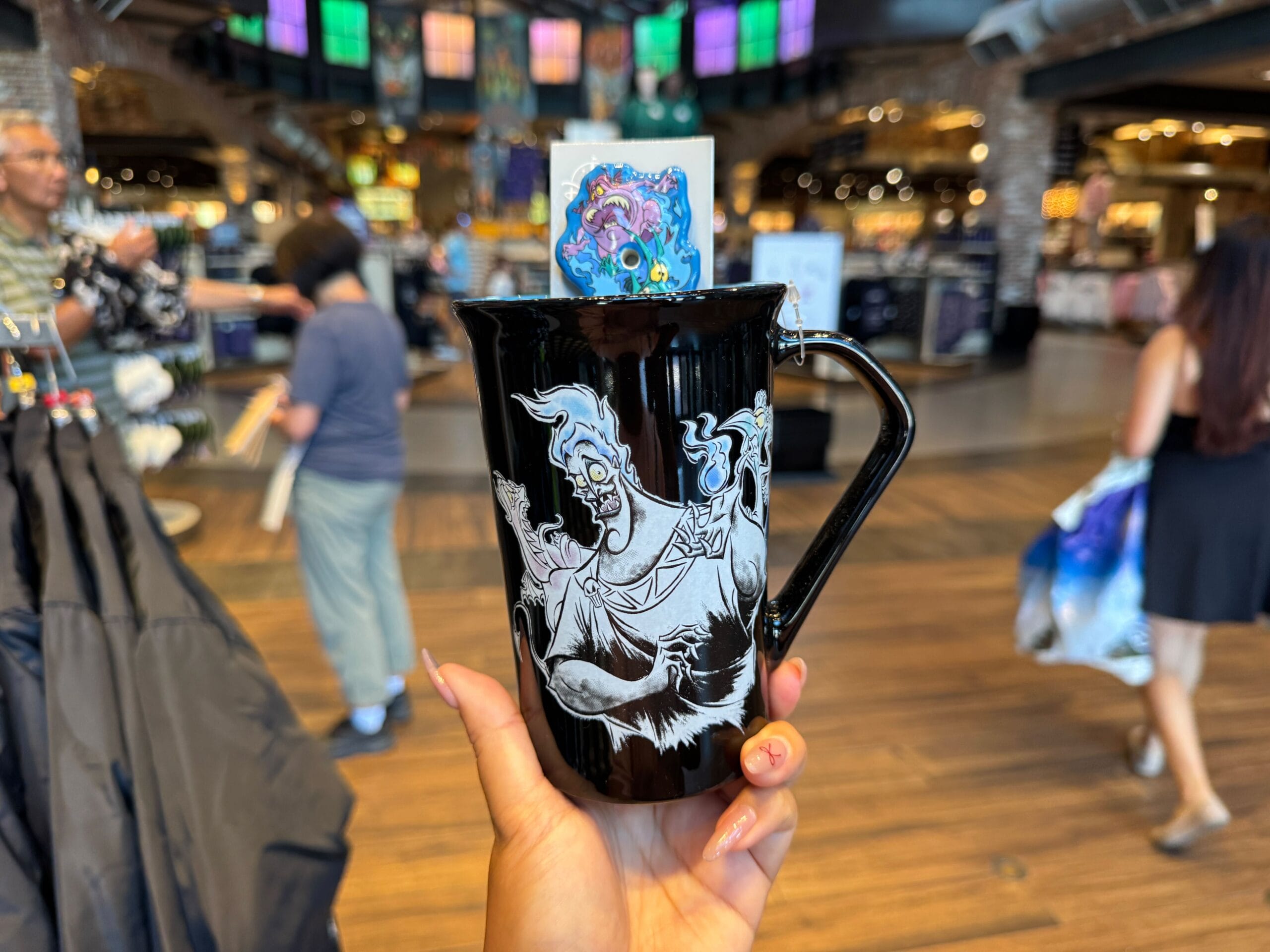 A hand holds a black mug featuring Disney’s Hades—perfect Disney Villains merchandise for Halloween 2025 shoppers.