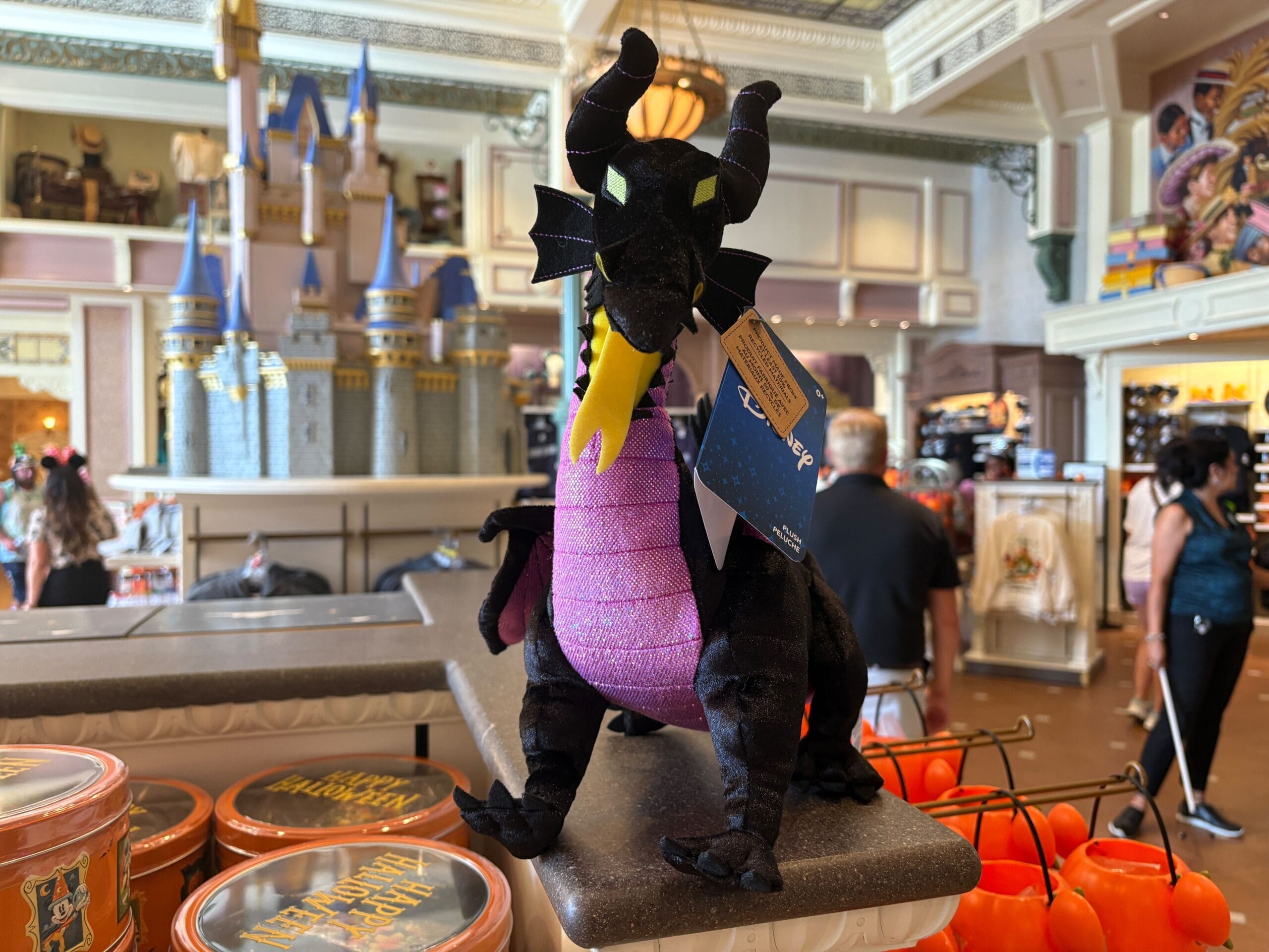 Plush Maleficent dragon toy on display among Disney Villains merchandise at Walt Disney World.