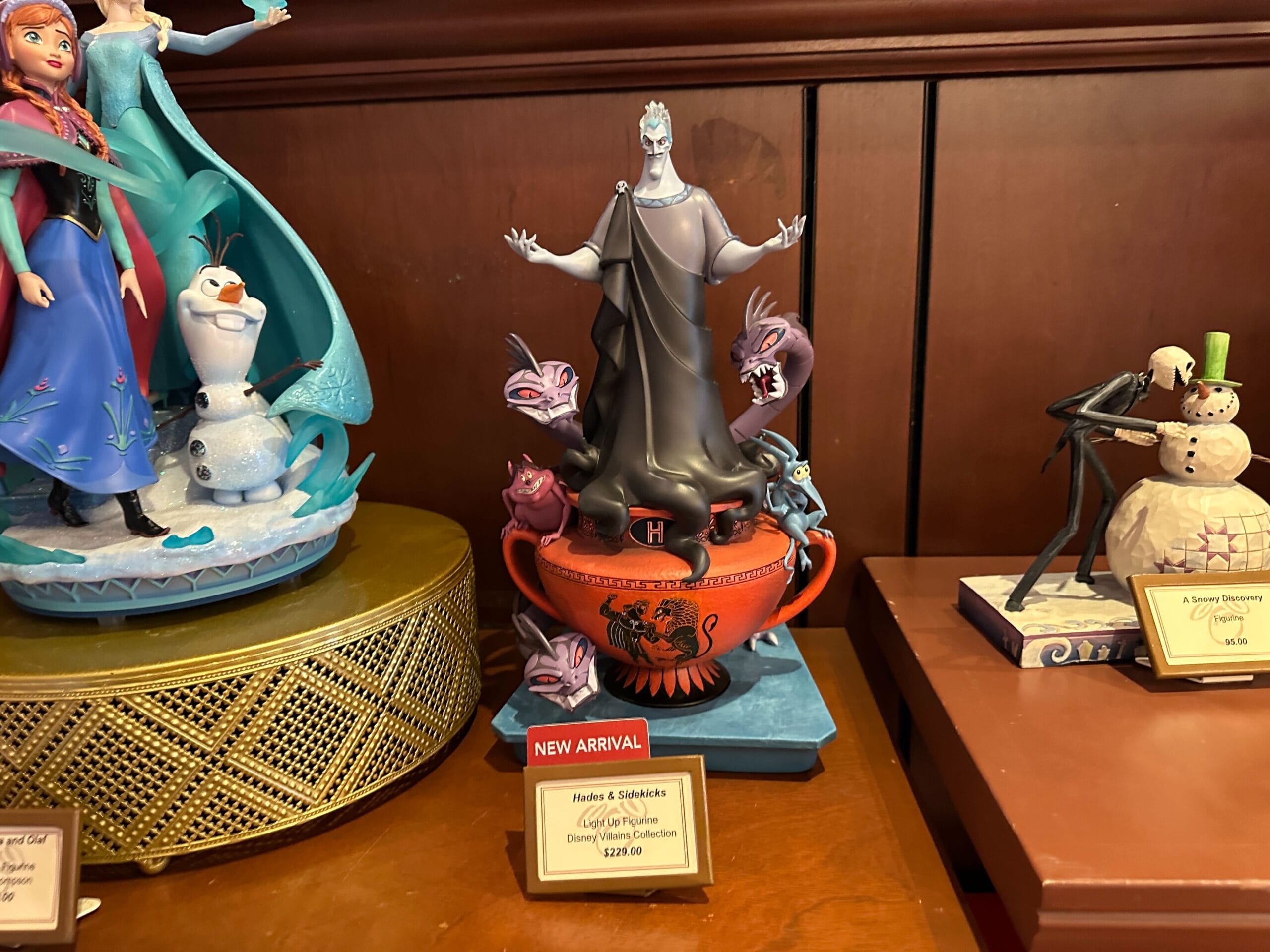 A Hades & sidekicks Disney figurine on a shelf, labeled "New Arrival," joins other Disney Villains Merchandise nearby.