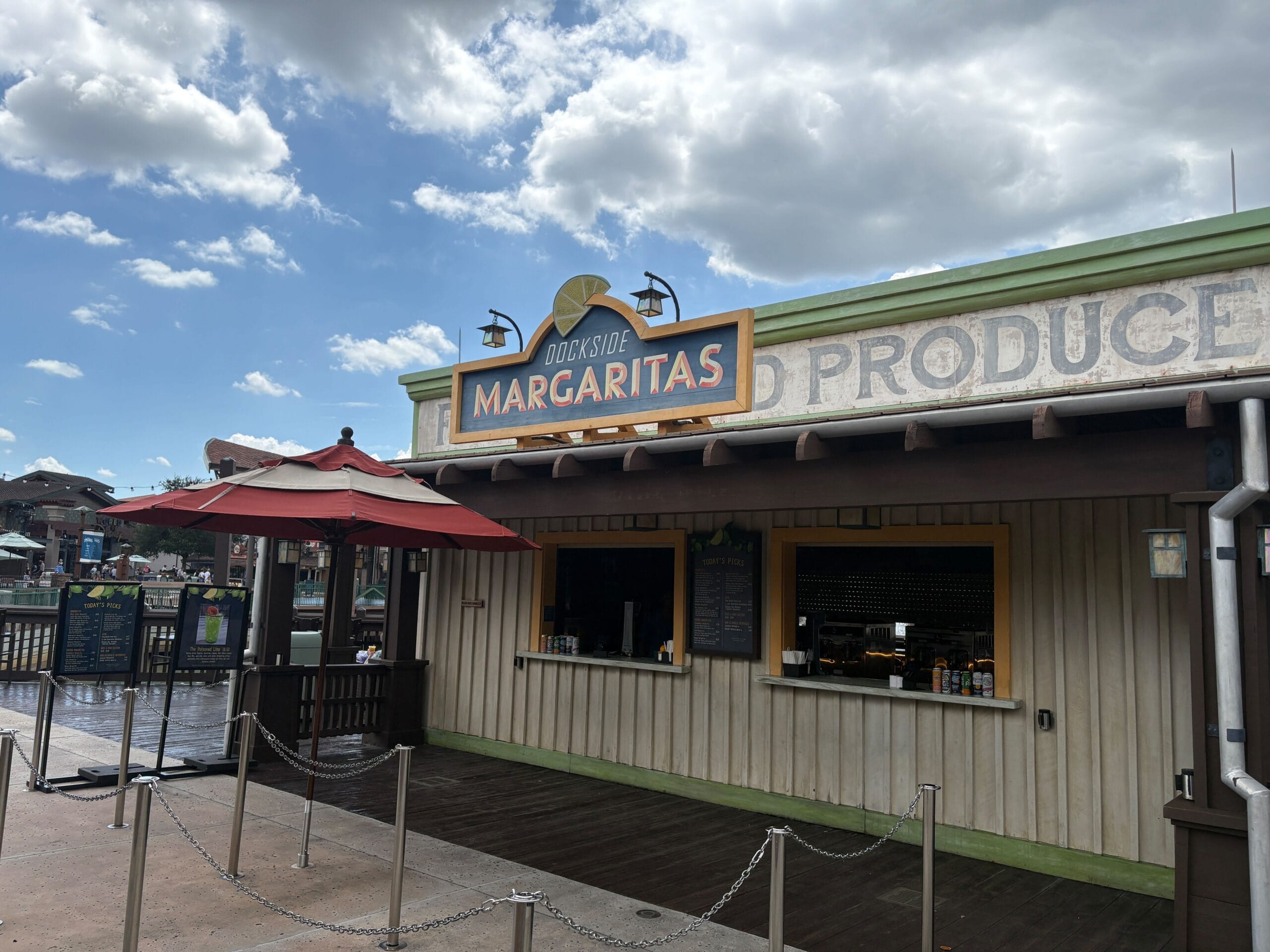 A small margarita stand at Disney Springs with a sign reading “Dockside Margaritas” under a partly cloudy sky.