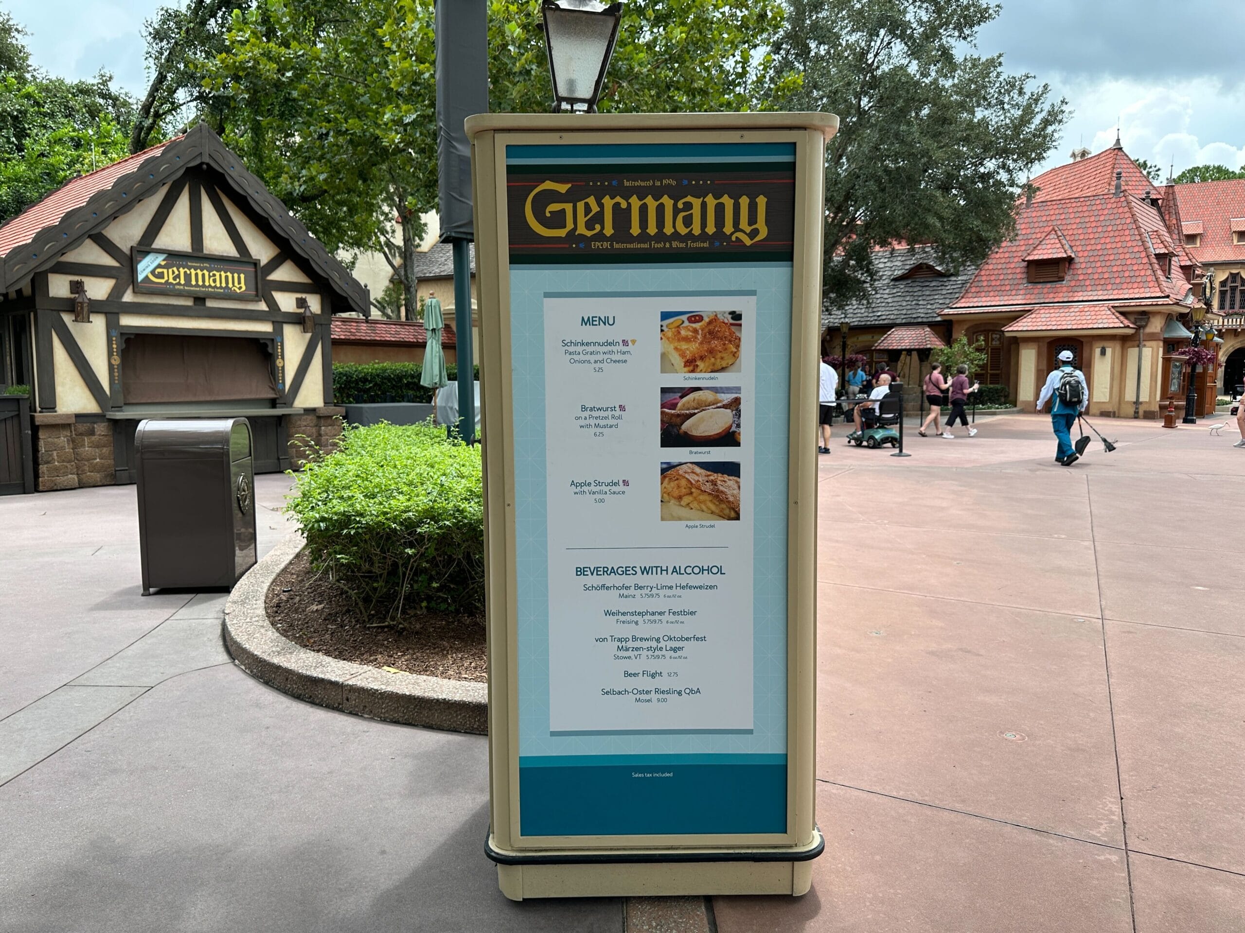 Outdoor menu board for the Germany pavilion at EPCOT’s Food & Wine Festival 2025, with buildings in the background.