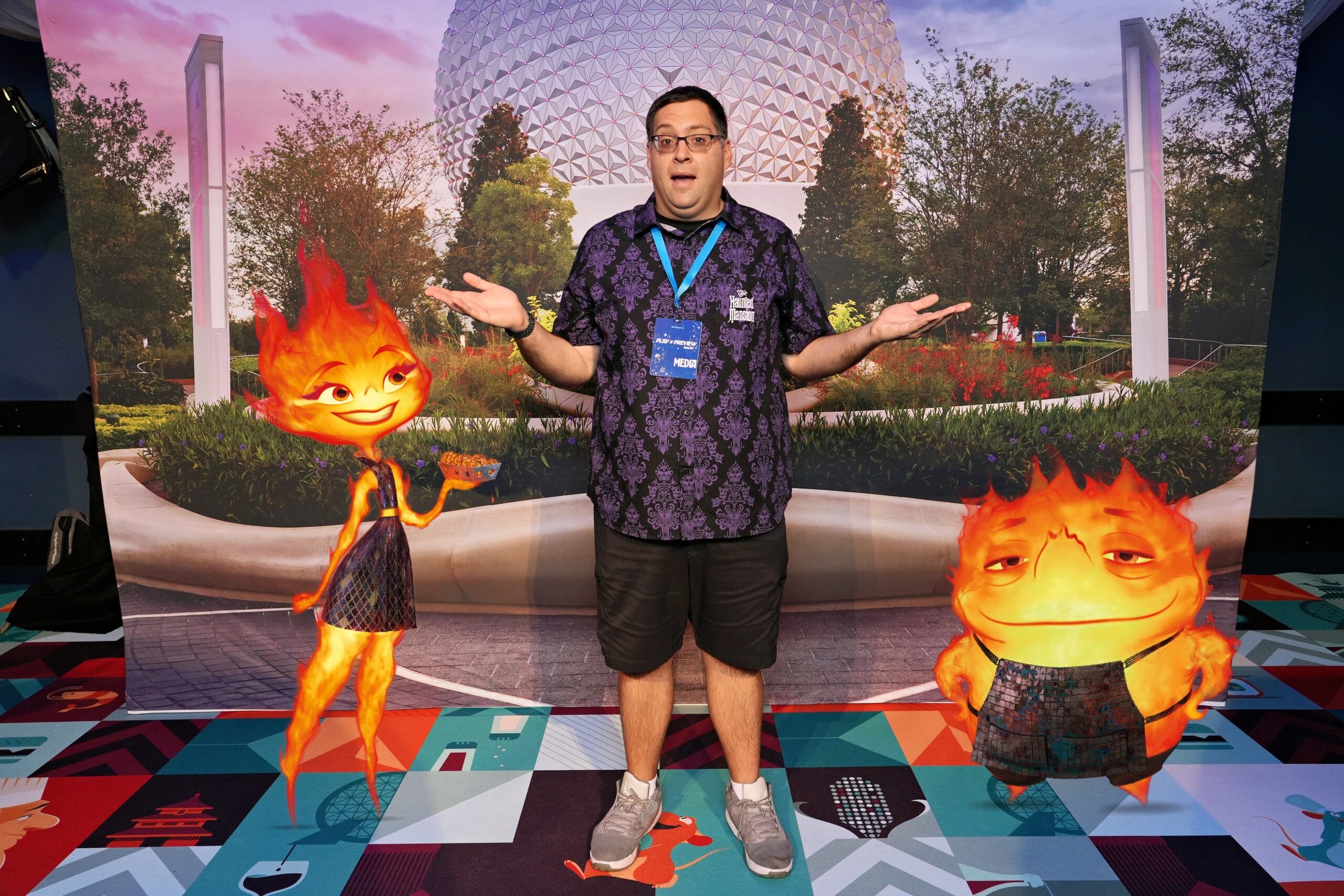 A man stands with two animated fire characters and a surprised shrug in a PhotoPass Magic Shot at the EPCOT Food & Wine Festival.