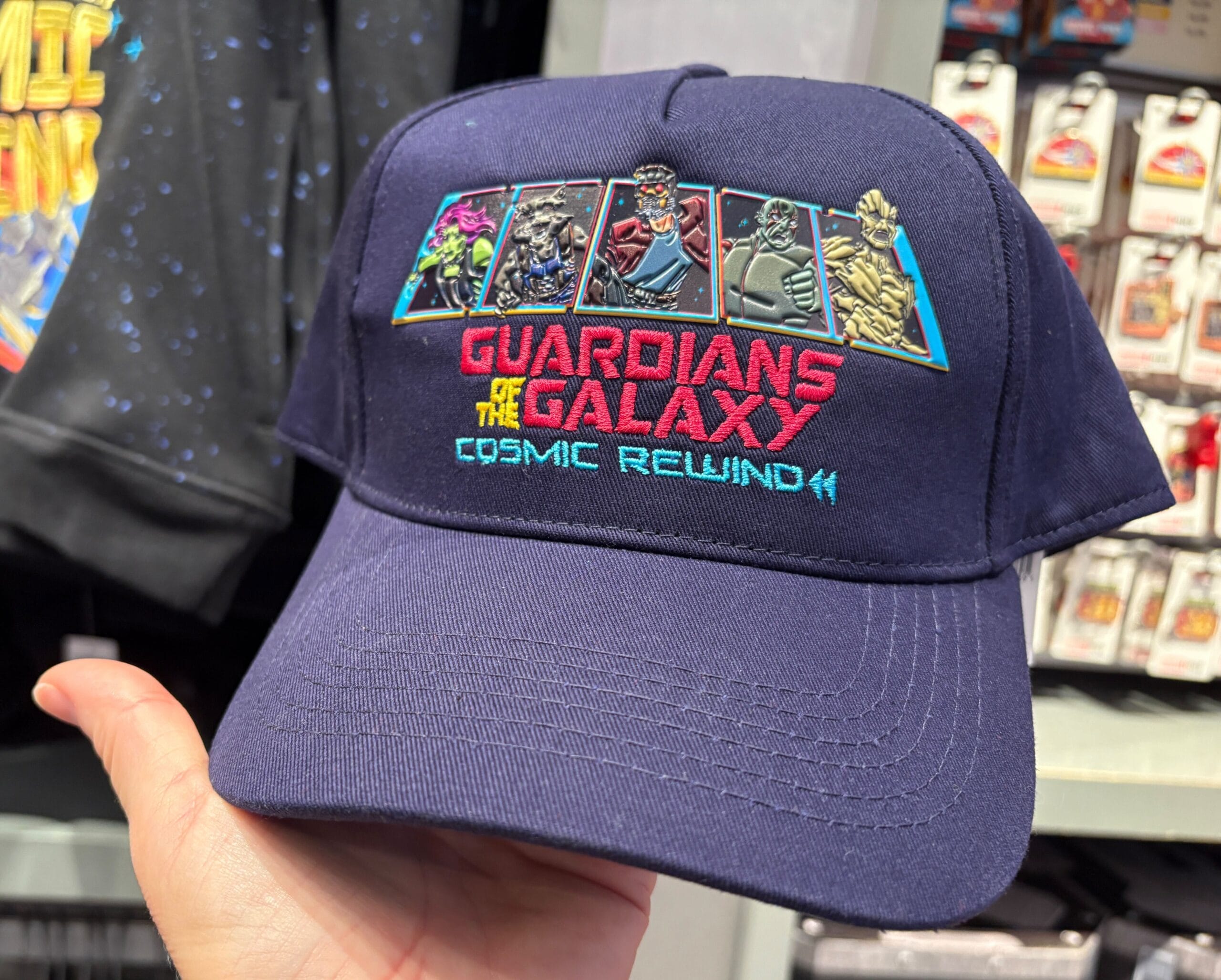 Navy blue hat with Guardians of the Galaxy Cosmic Rewind logo and characters in colorful panels on the front.