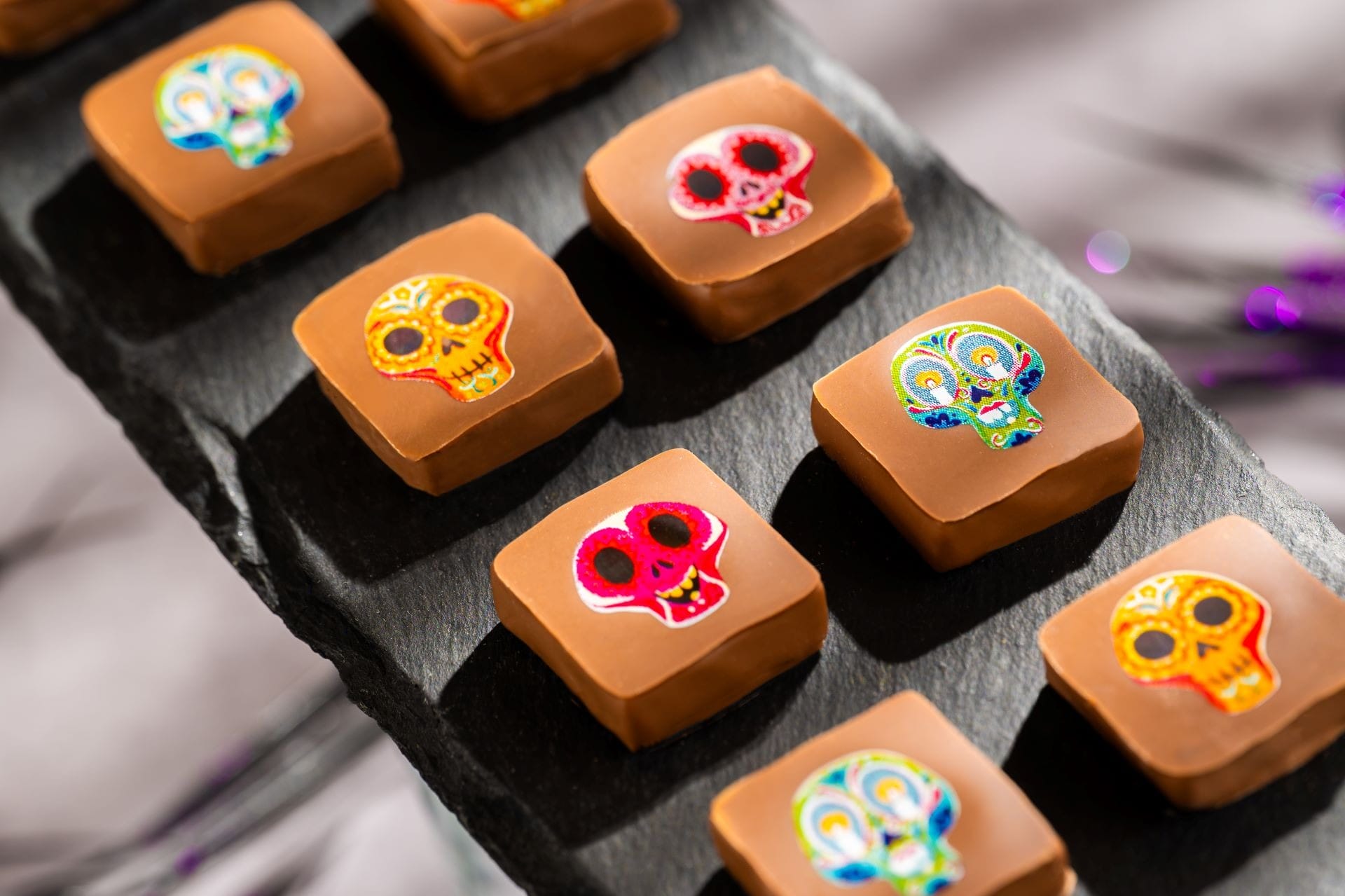 Square chocolates with colorful sugar skulls, perfect as 2025 Halloween treats at Walt Disney World.