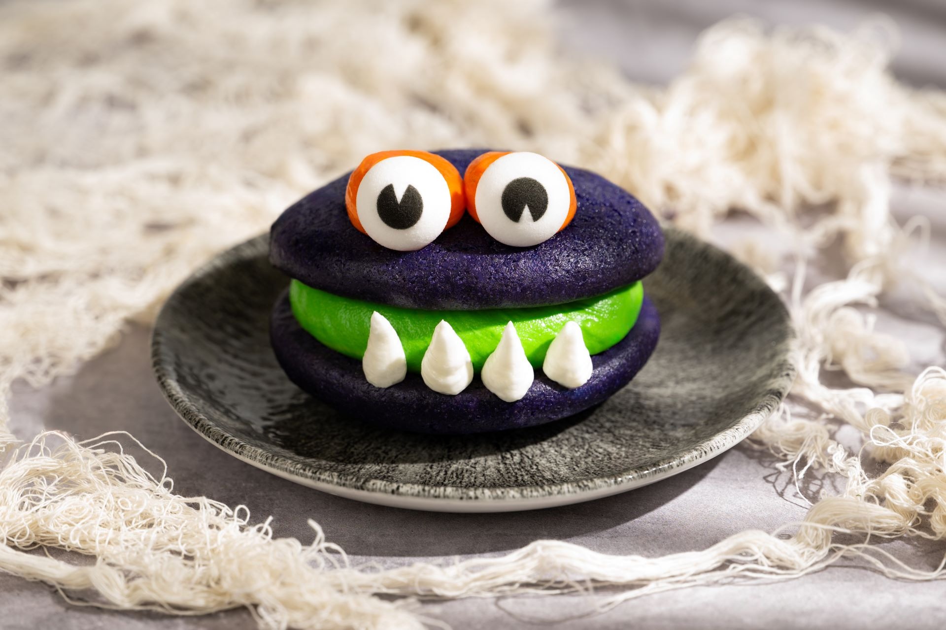A purple monster-themed cookie sandwich with green filling, perfect for 2025 Halloween treats at Walt Disney World.