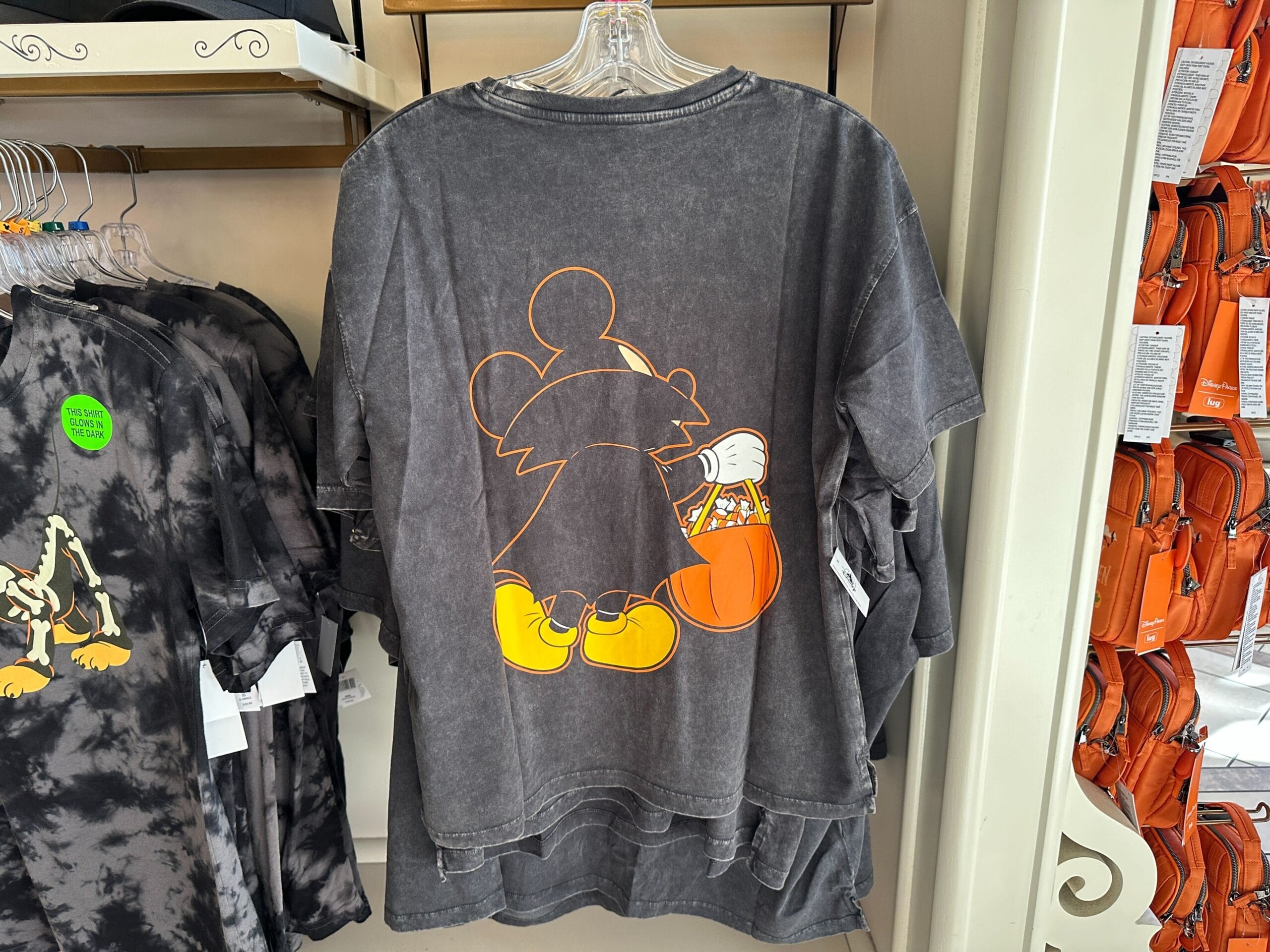 Gray T-shirt featuring an orange-outlined Mickey with a pumpkin candy bucket—Disney Halloween Merch 2025 in store now.