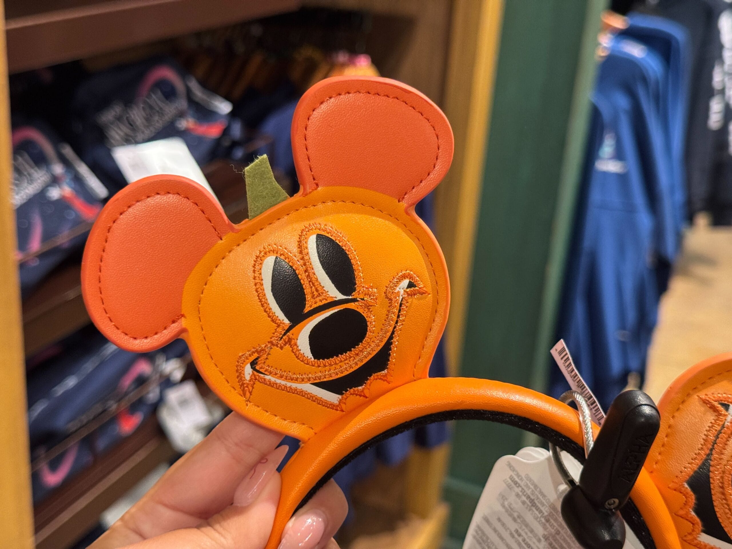 Orange Mickey Mouse ears headband with a pumpkin design—festive Halloween merchandise at Walt Disney World.
