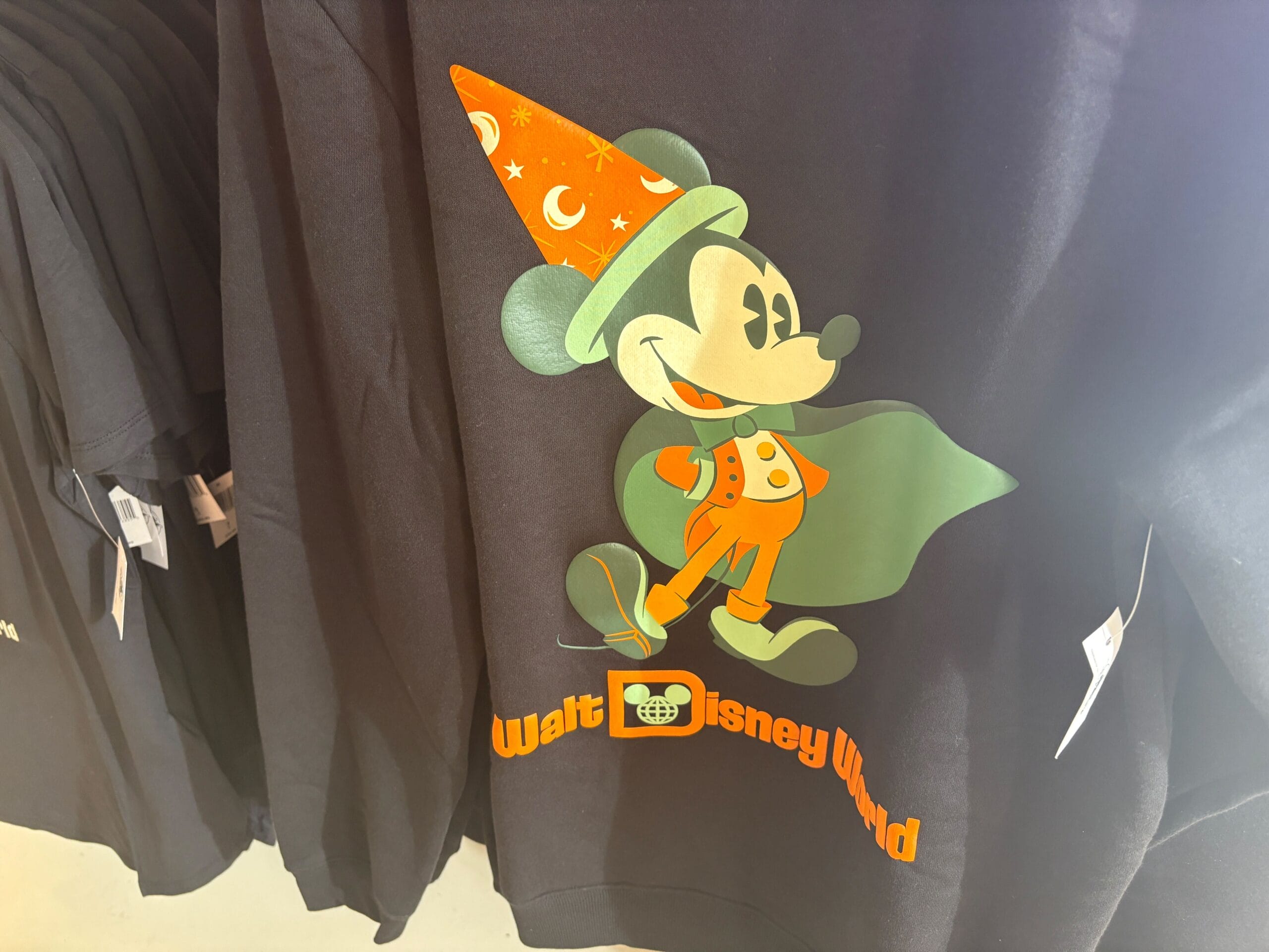 Black shirt with Mickey Mouse in a wizard hat and cape—perfect Halloween merchandise from Walt Disney World.