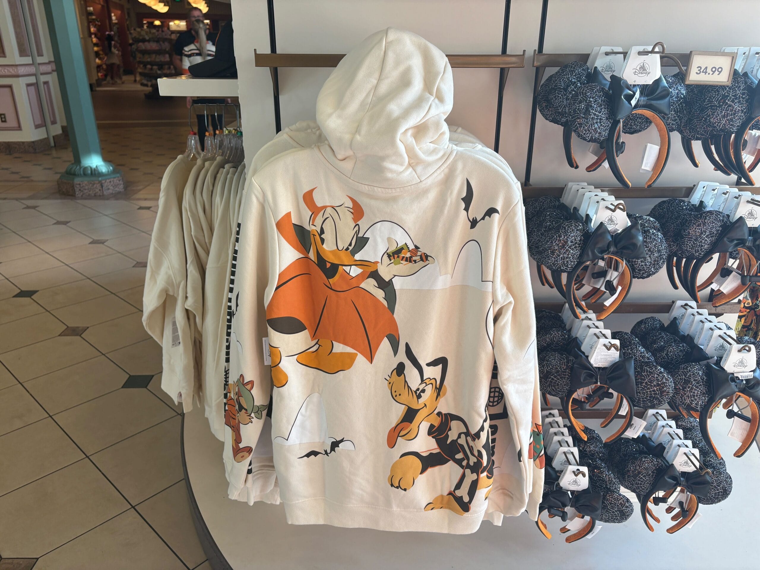 White hoodie with Disney’s Donald Duck in a vampire costume and Pluto, part of Walt Disney World Halloween merchandise.