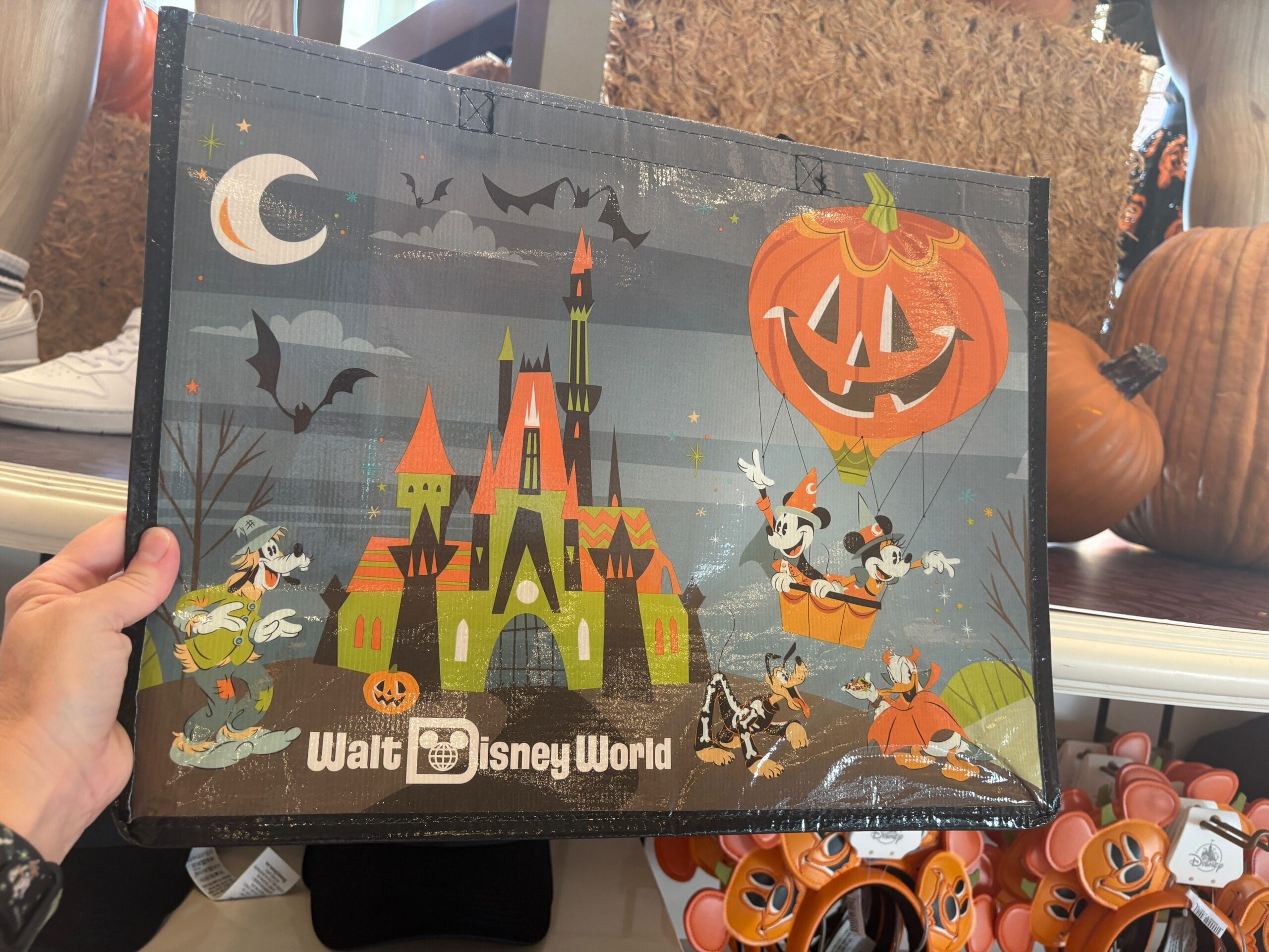 A Halloween Merchandise bag from Walt Disney World with characters, a castle, bats, and pumpkins.