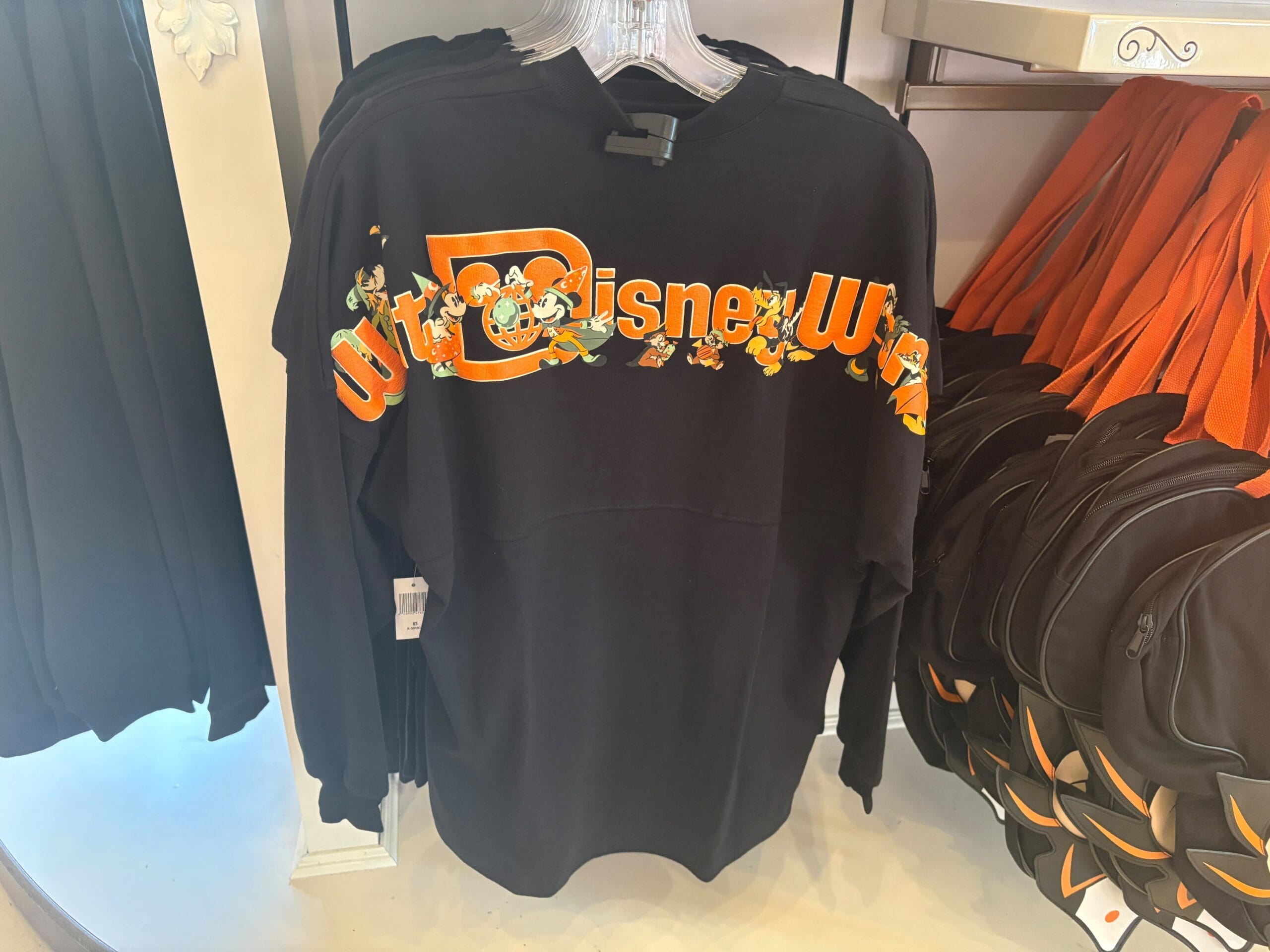 Disney Halloween Merch 2025 - Black Walt Disney World sweatshirt with orange and yellow lettering and classic Disney characters across the chest.