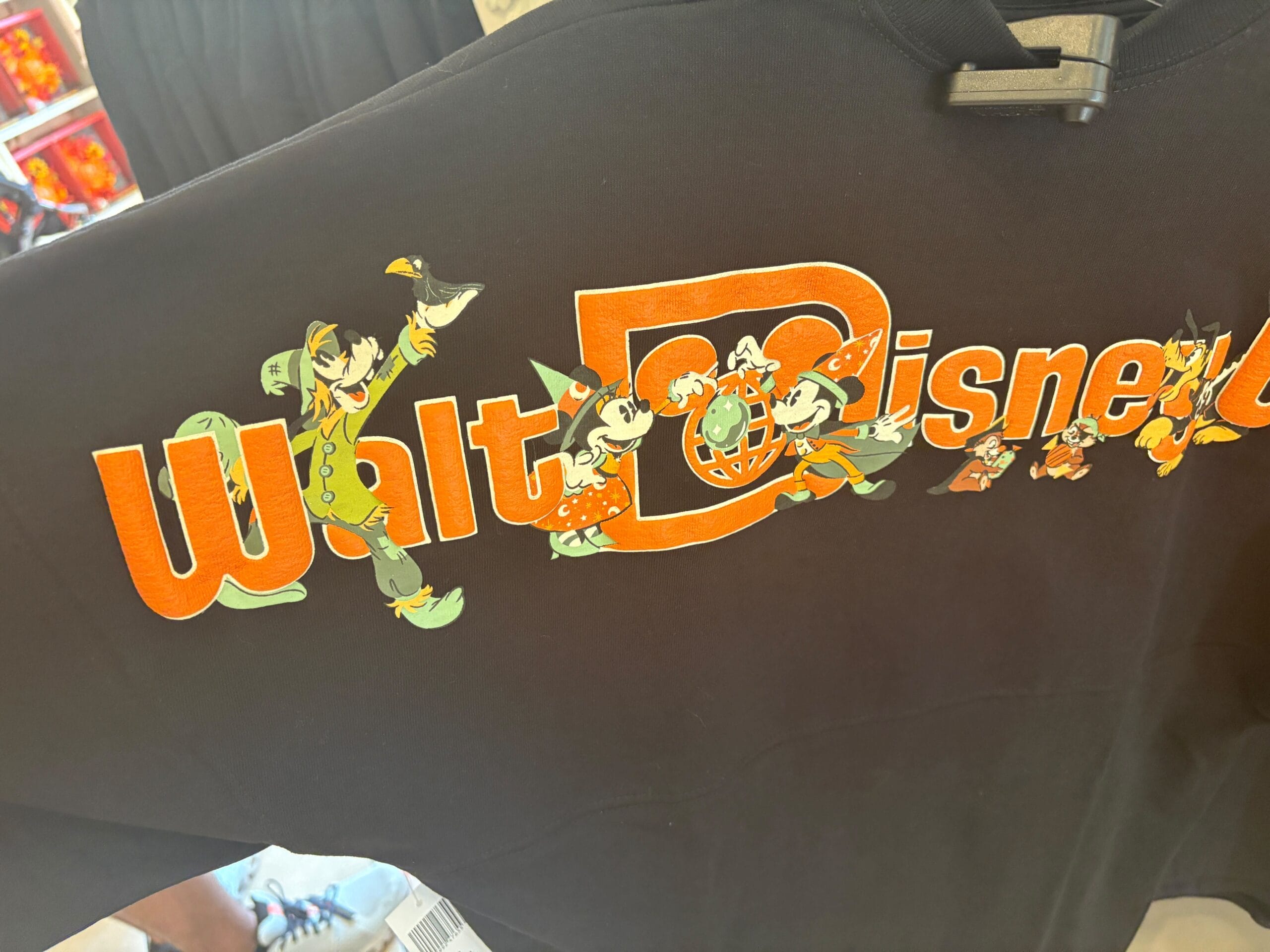 Black shirt with "Walt Disney" text, featuring classic Disney characters—a must-have for Walt Disney World fans.