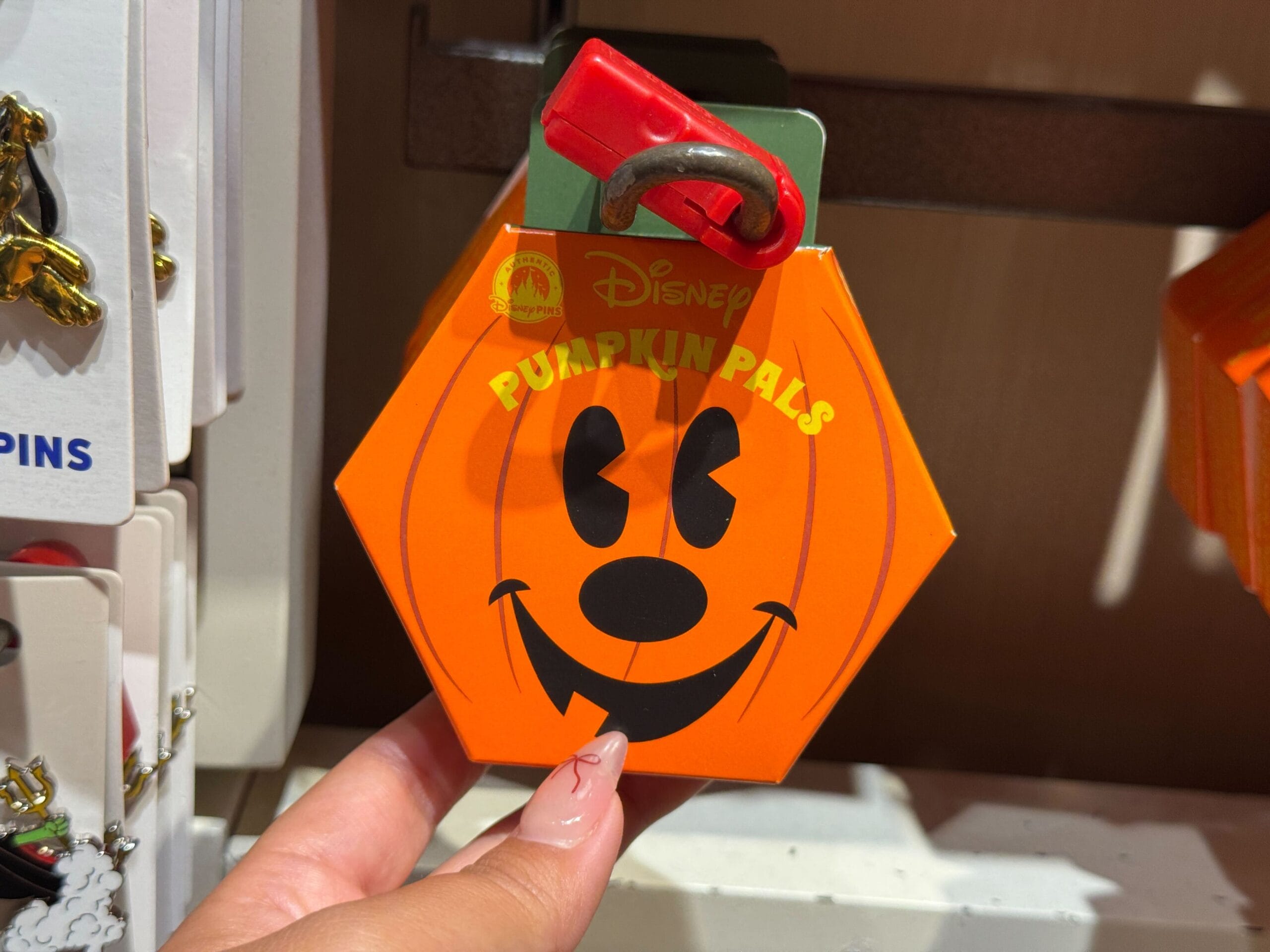 Hand holding a 2025 Halloween merchandise Disney Pumpkin Pals box with a red clip at Walt Disney World.