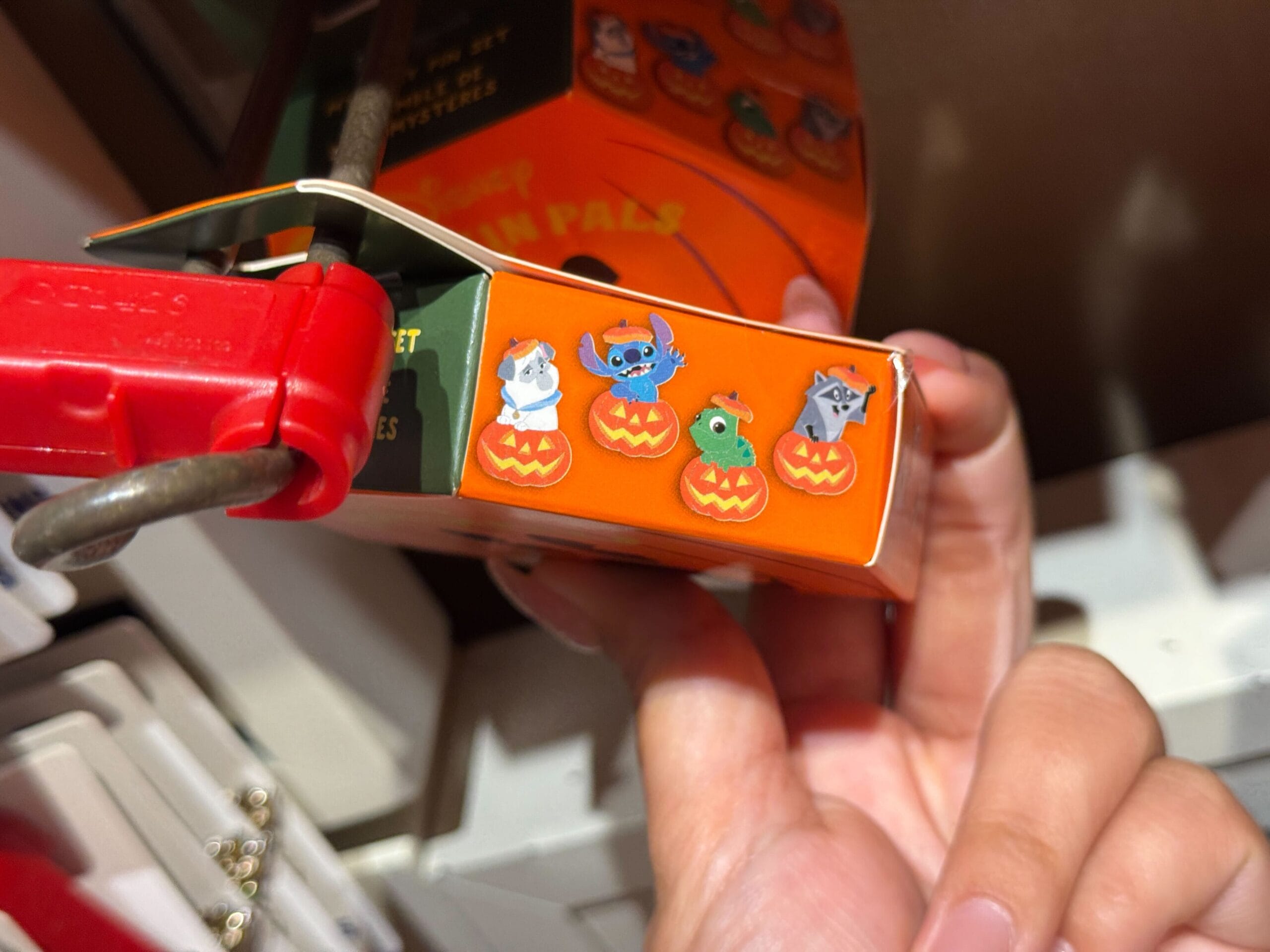 Four cartoon characters, including Stitch, in Halloween costumes in jack-o'-lanterns on 2025 Halloween Merchandise box.